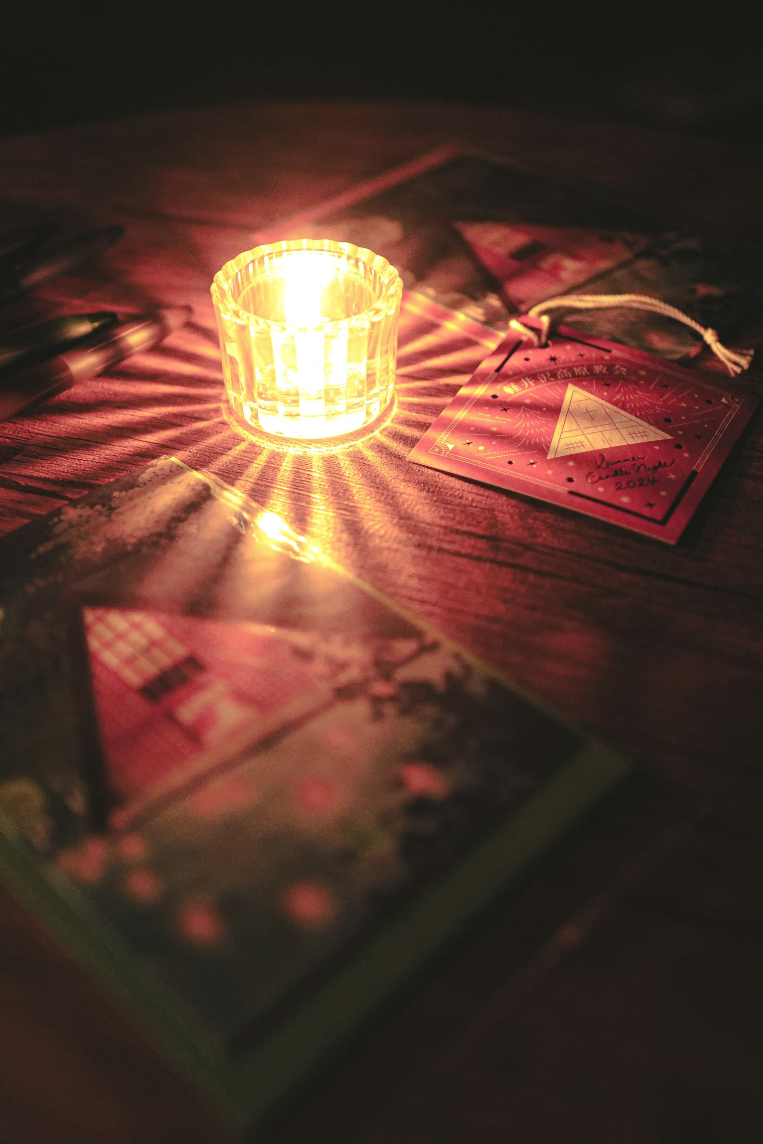 Colorful cards arranged around a glowing candle on a dark wooden table