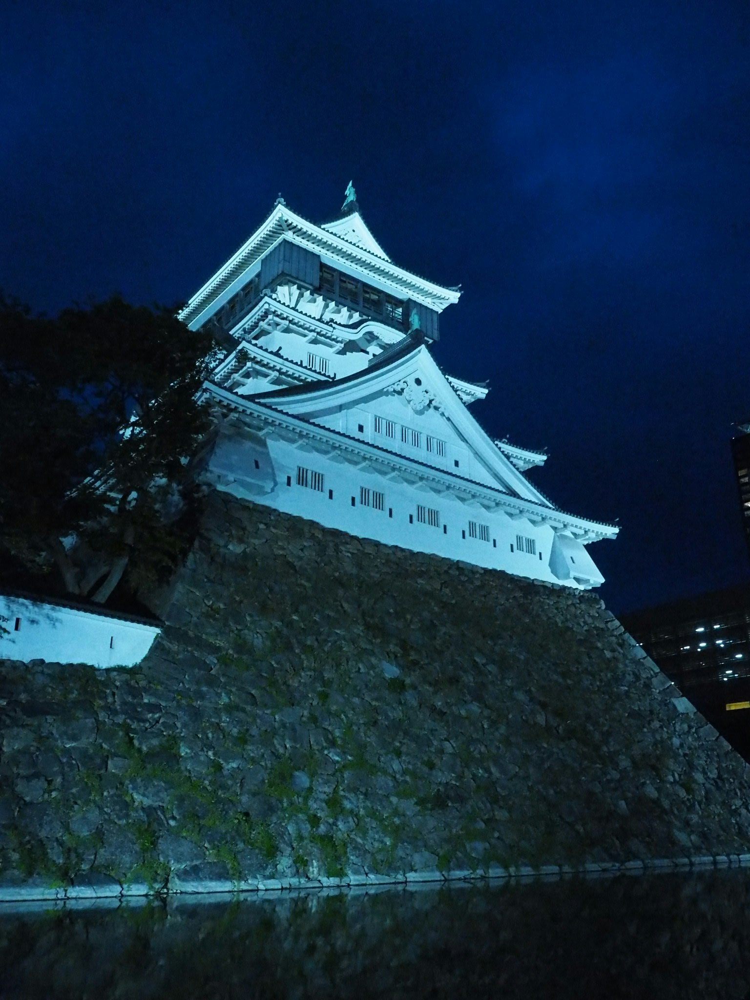 โครงสร้างปราสาทสีขาวที่ถูกไฟสีน้ำเงินส่องสว่างในตอนกลางคืน