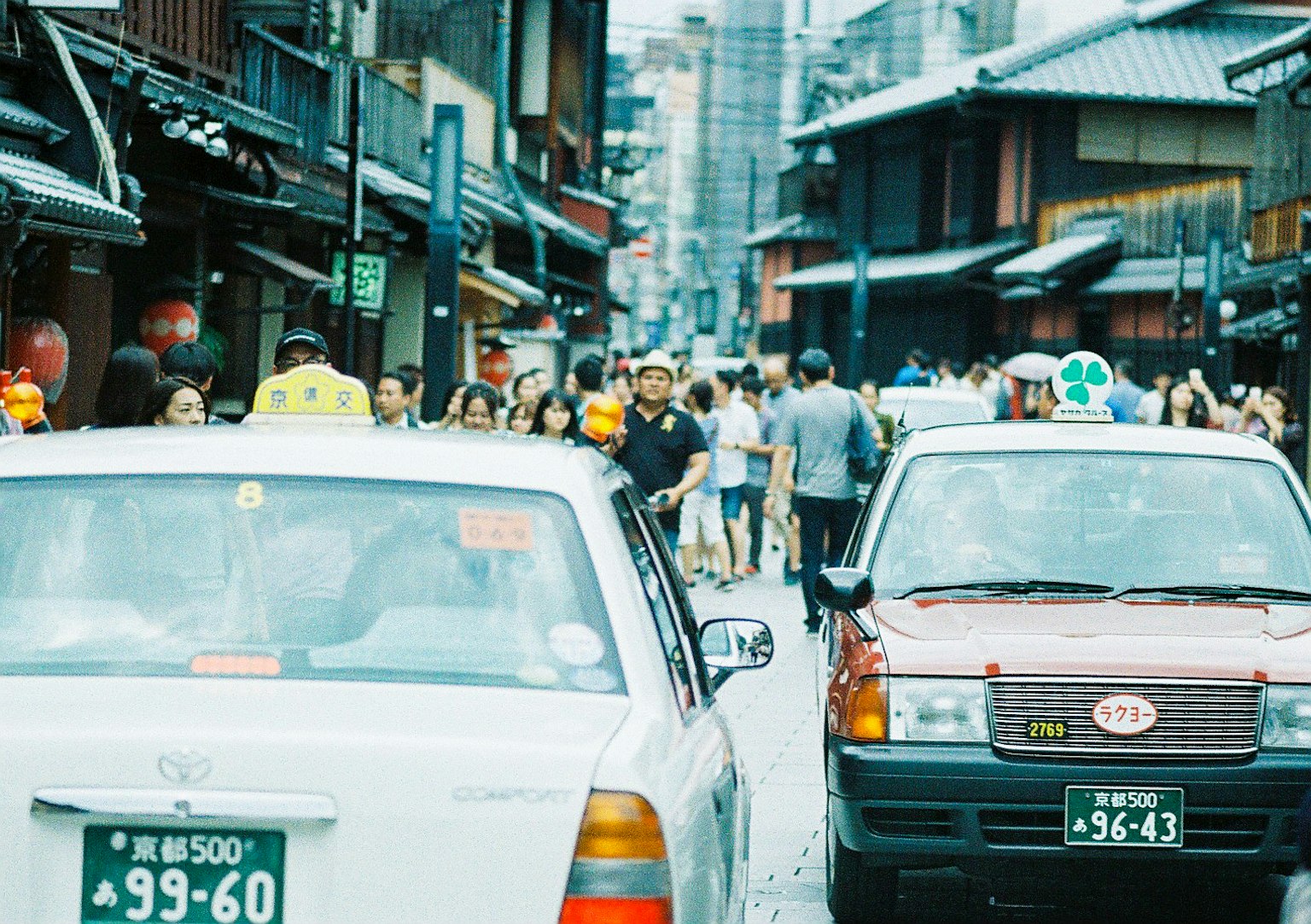 Taxis, die an einer überfüllten Straße mit traditionellen Gebäuden angehalten sind