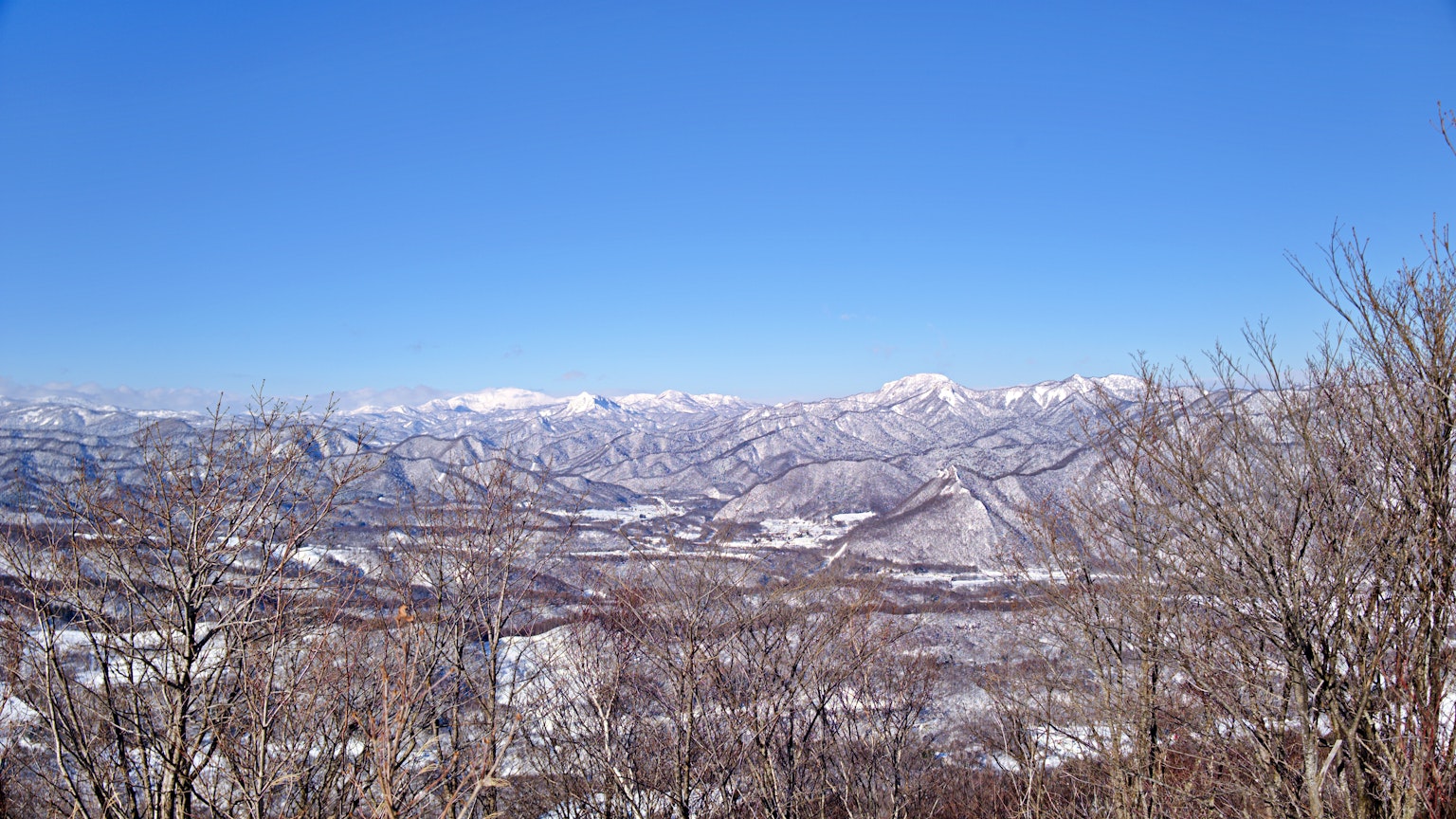 맑은 파란 하늘 아래 눈 덮인 산