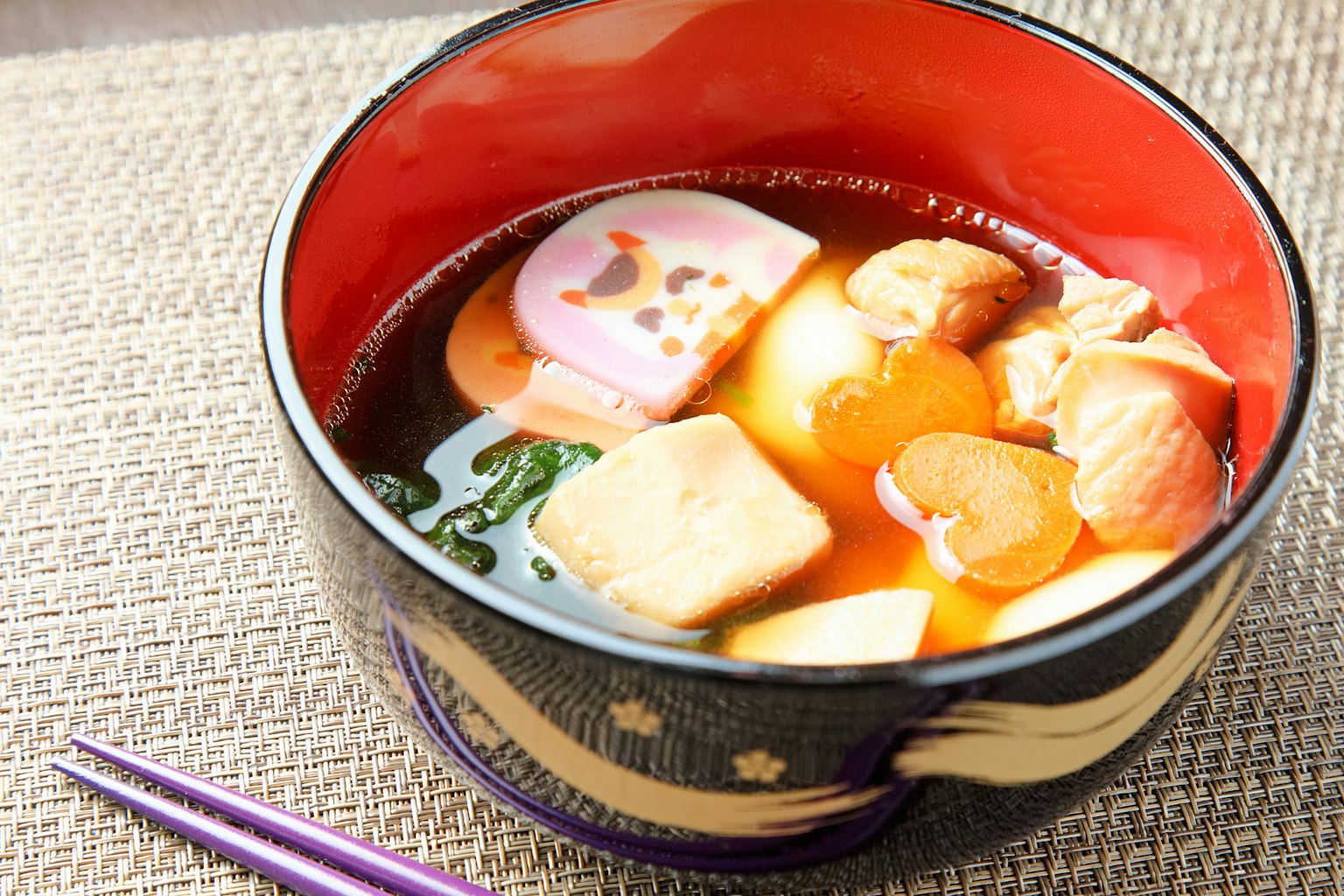 Sup miso dalam mangkuk merah yang indah dengan ikan, sayuran, dan kamaboko