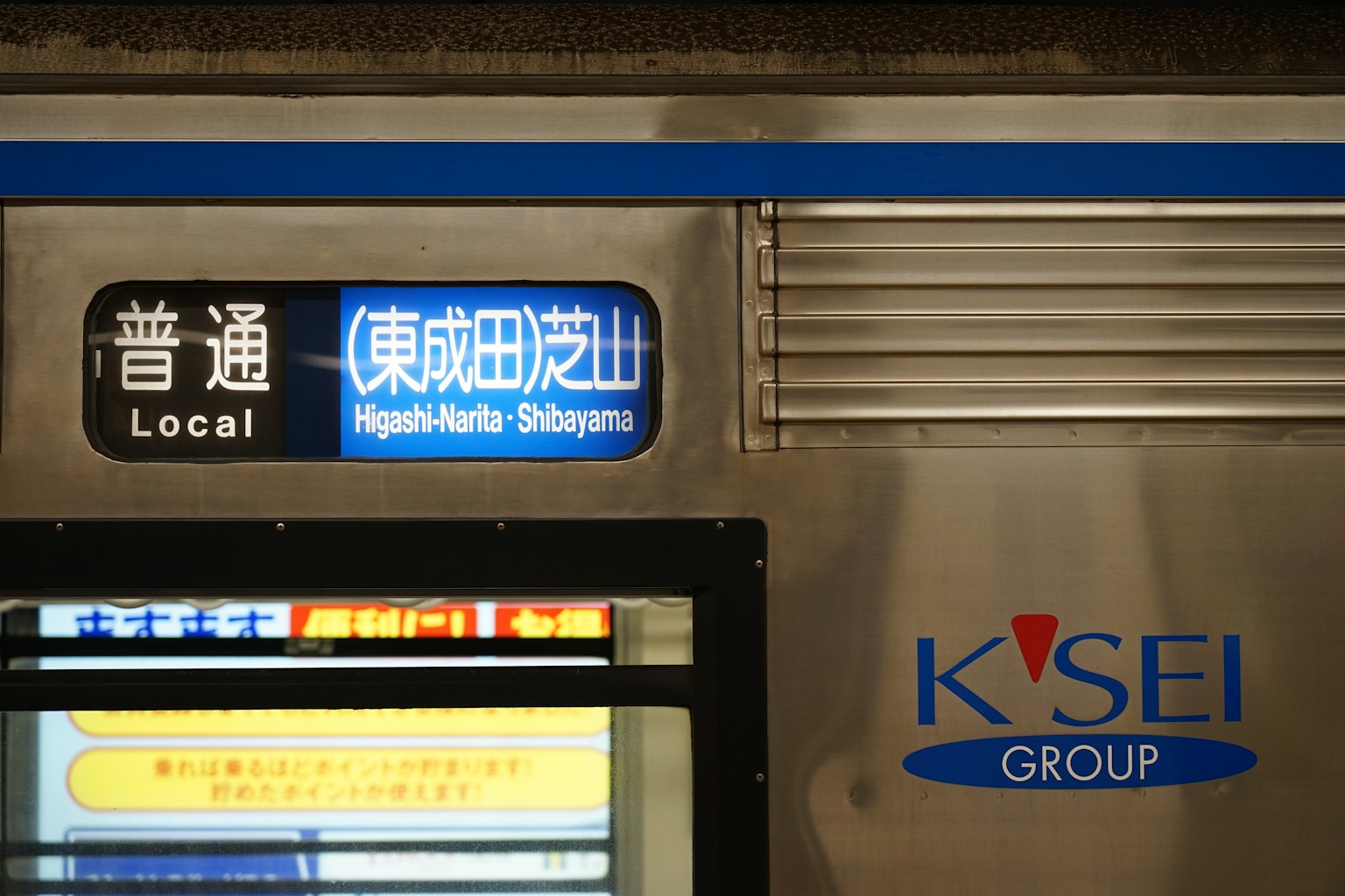Segnale di treno locale e nome della stazione sul lato di un treno del gruppo Keisei