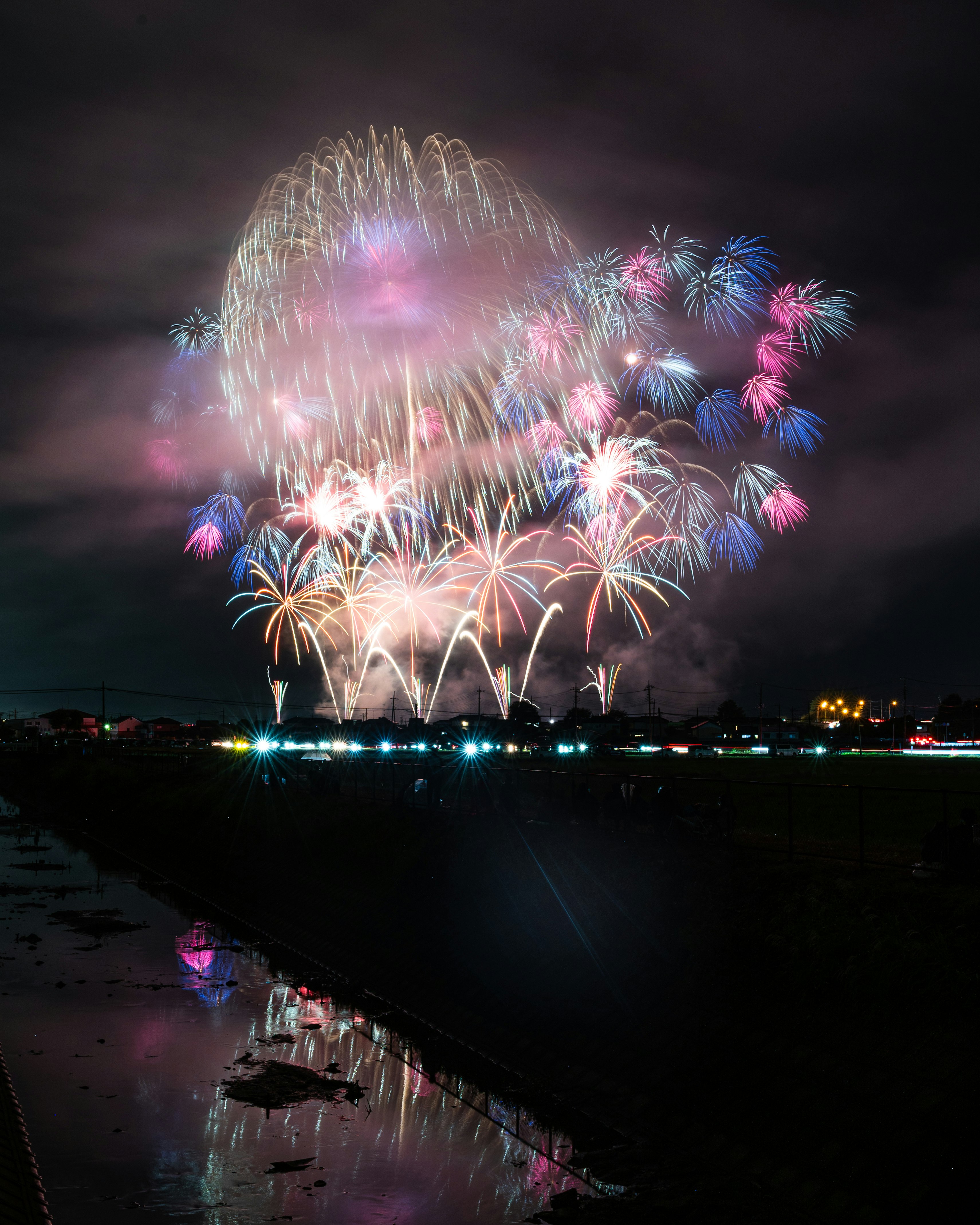 夜空に咲く花火と水面に映る光の大輪