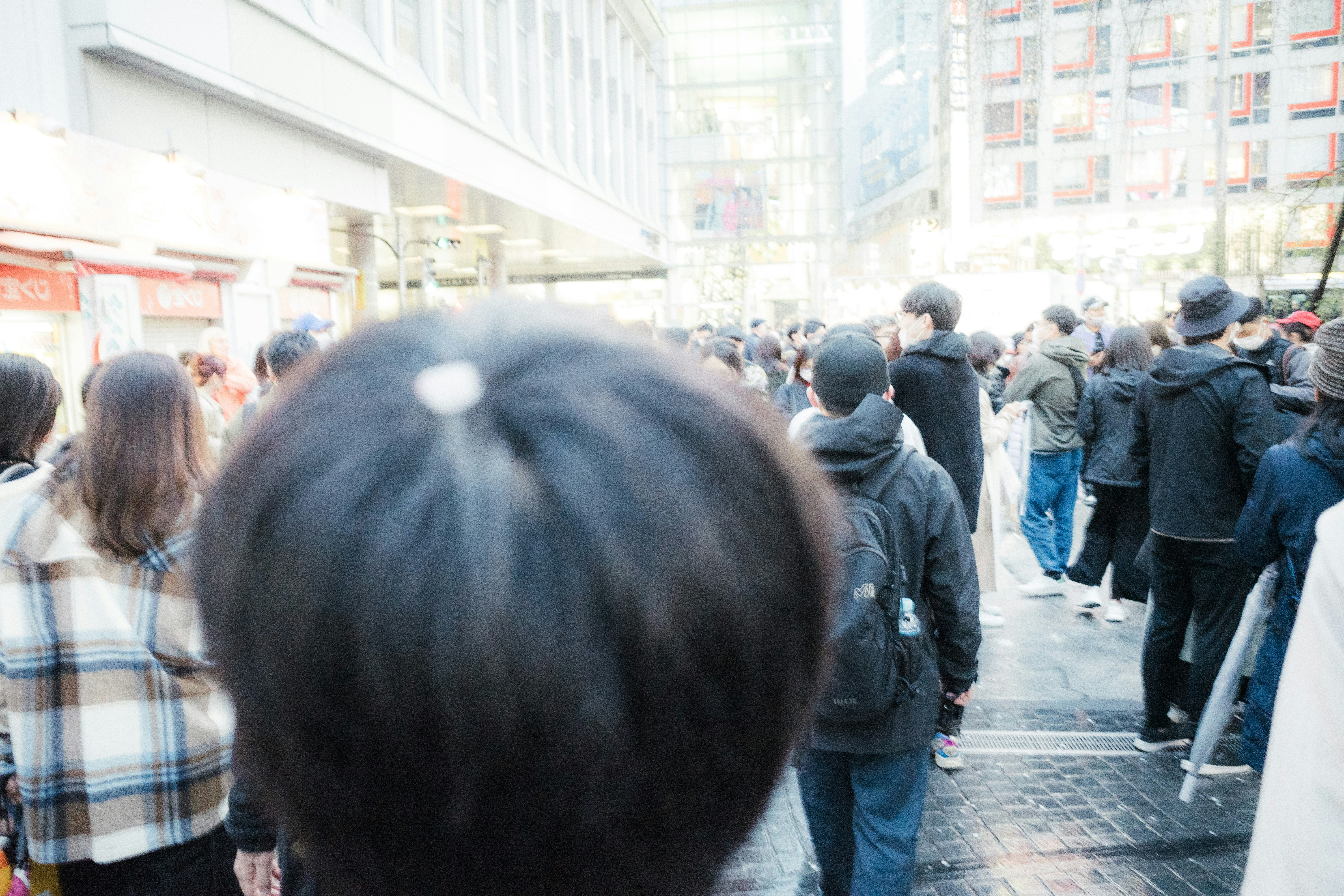 vue de dos de personnes faisant la queue sur un quai de gare