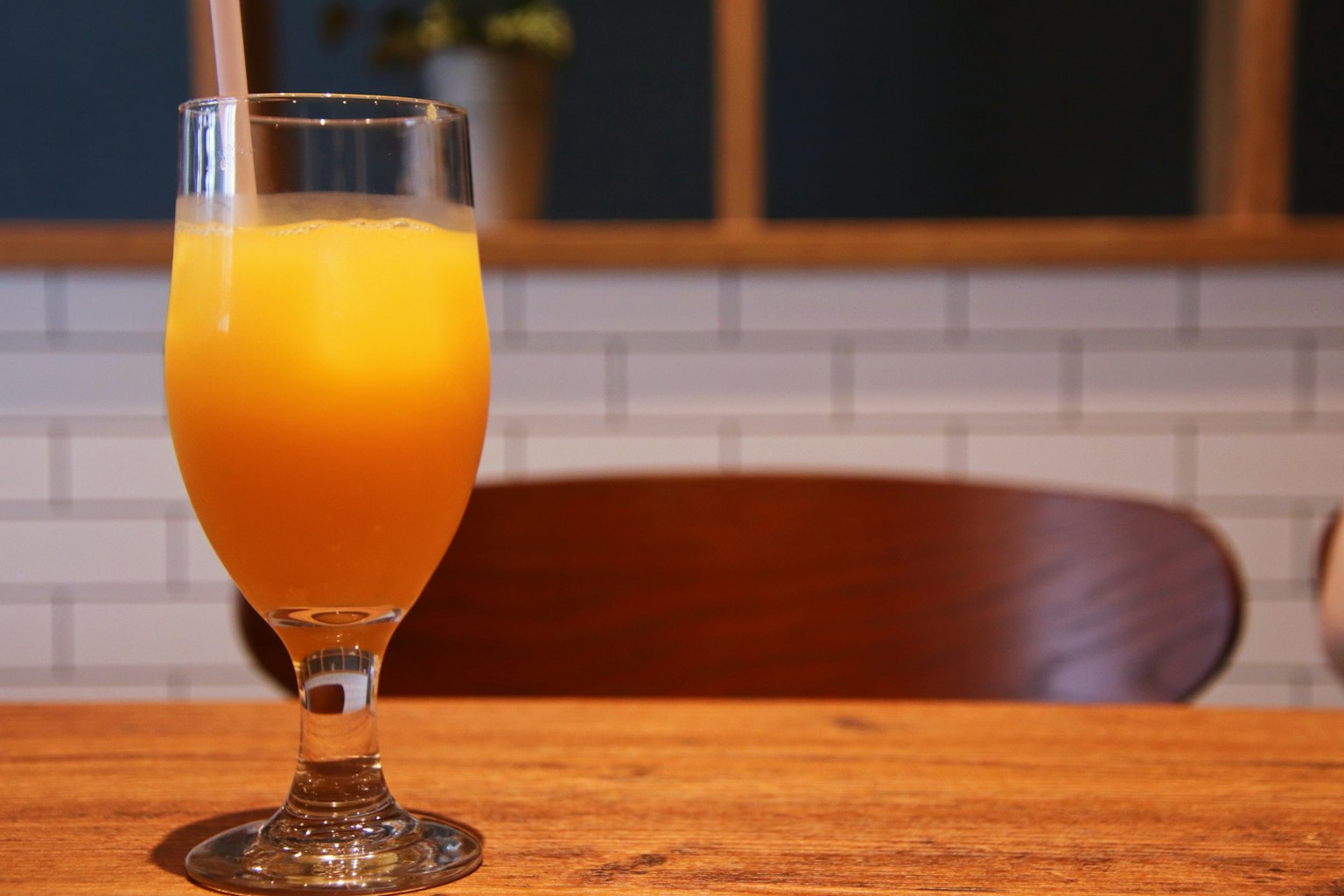 A glass of orange juice on a wooden table