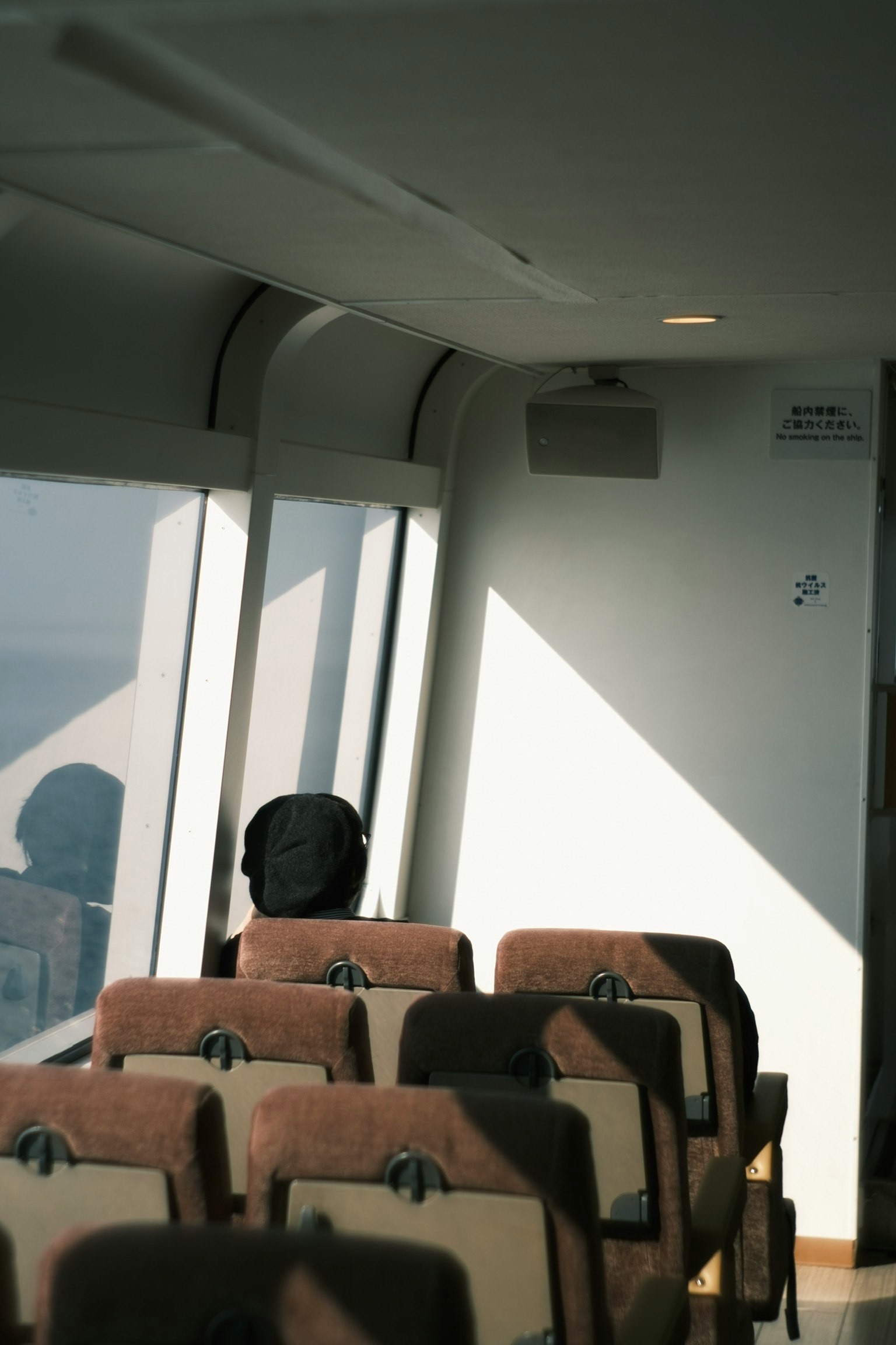 窓際に座る人と空席のある室内の風景
