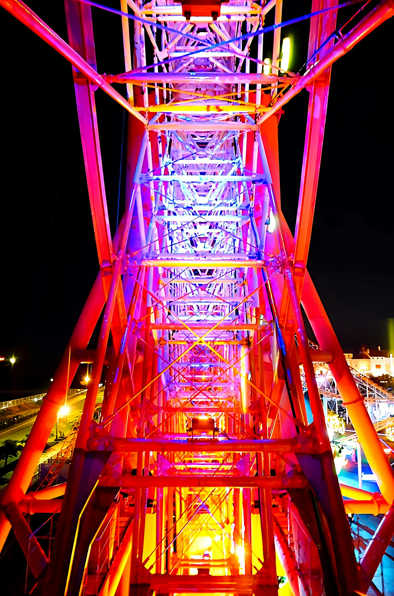 Colorful structure of a Ferris wheel illuminated at night