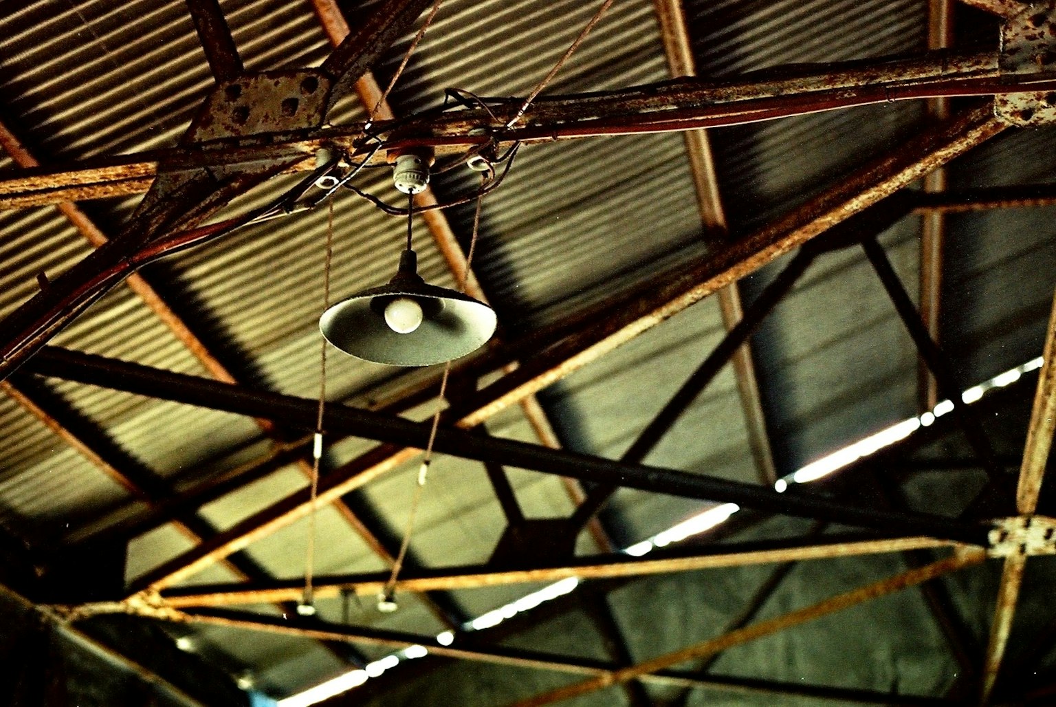 Lampe suspendue et poutres métalliques du plafond d'une vieille usine