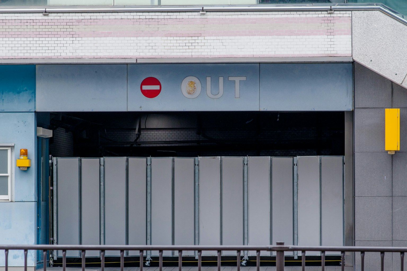 Blue building entry with an 'OUT' sign and a red no entry symbol