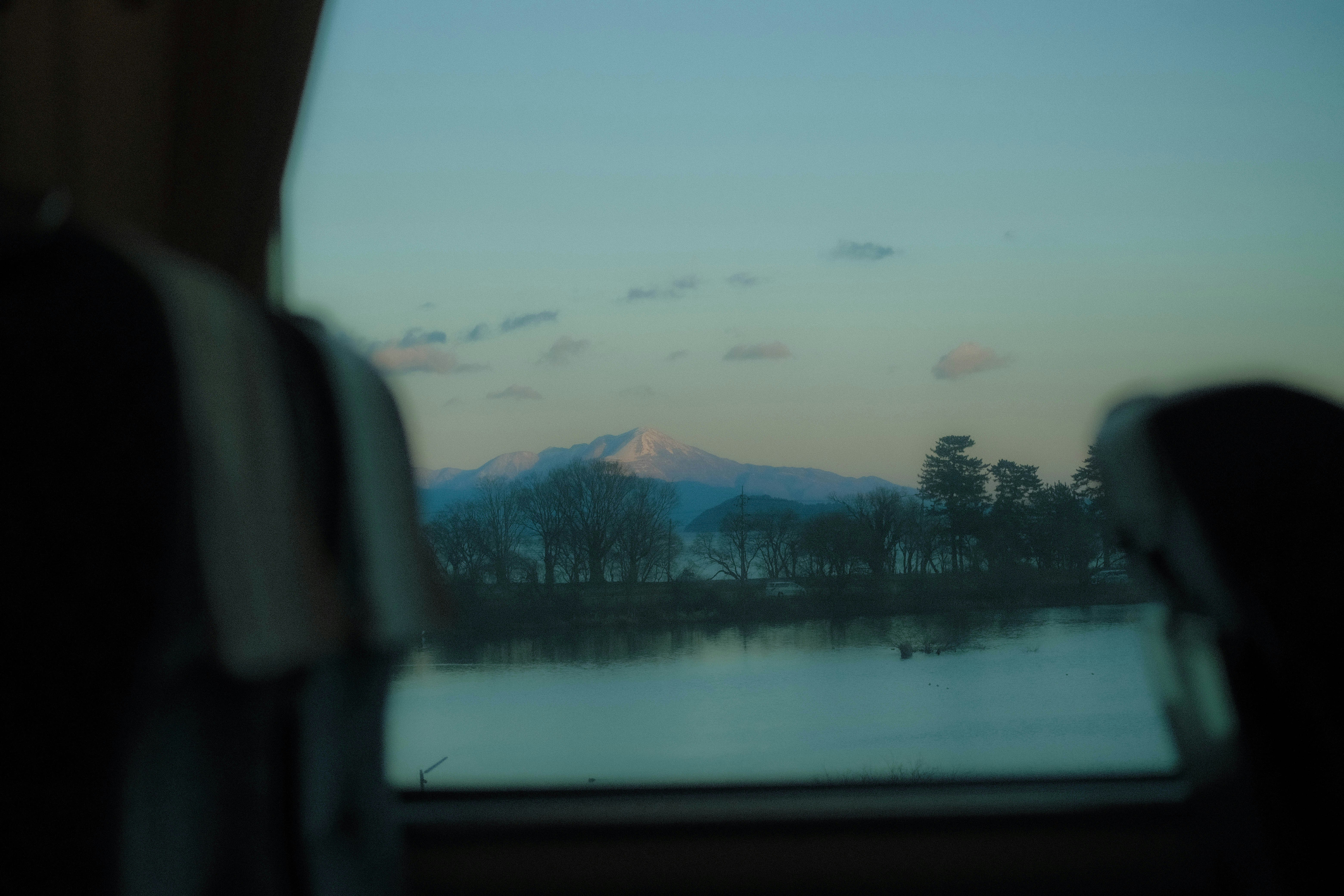 車窓から見える湖と山並みの風景