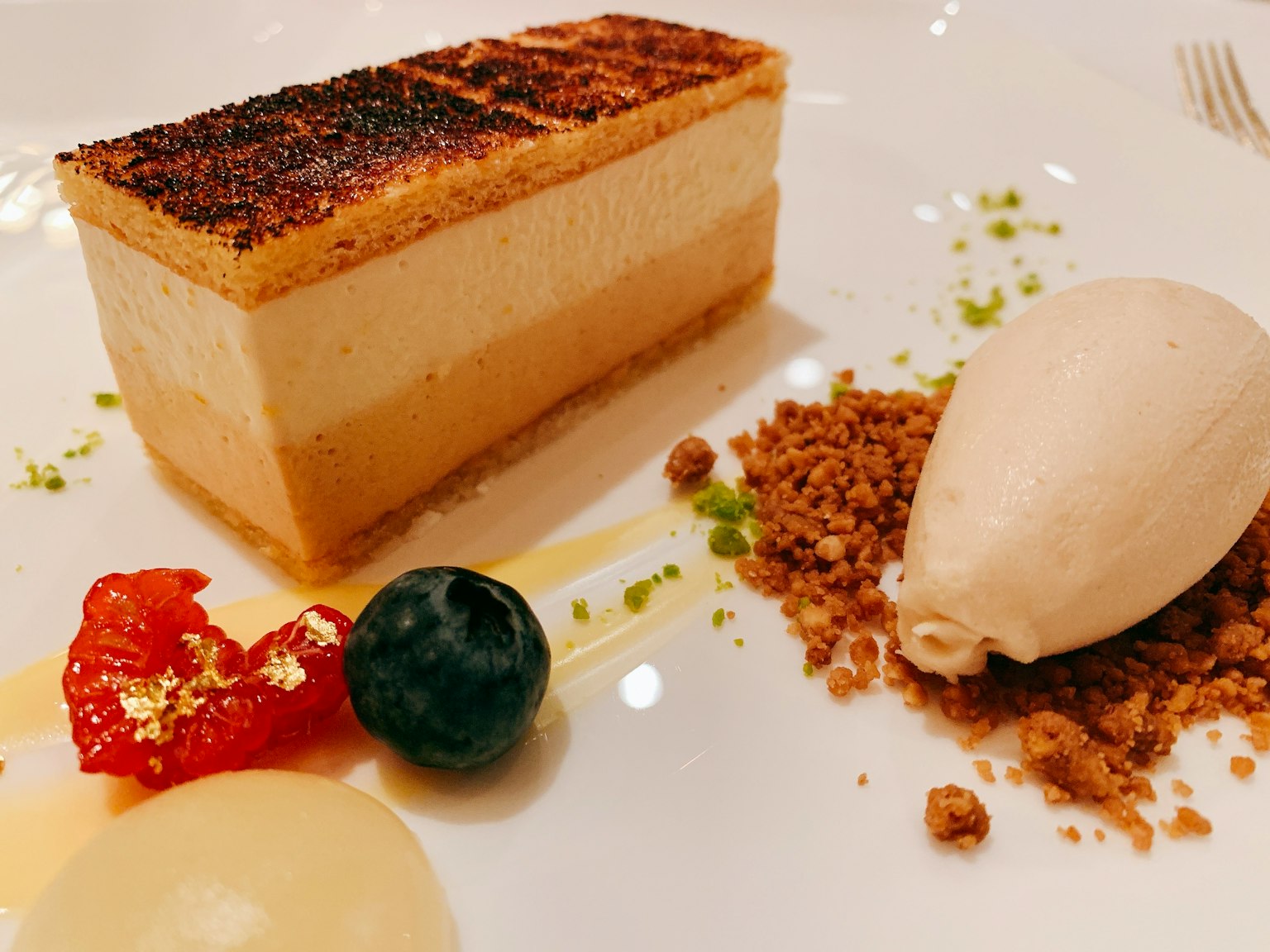 Fetta di dessert cremoso con gelato e guarnizioni di frutta