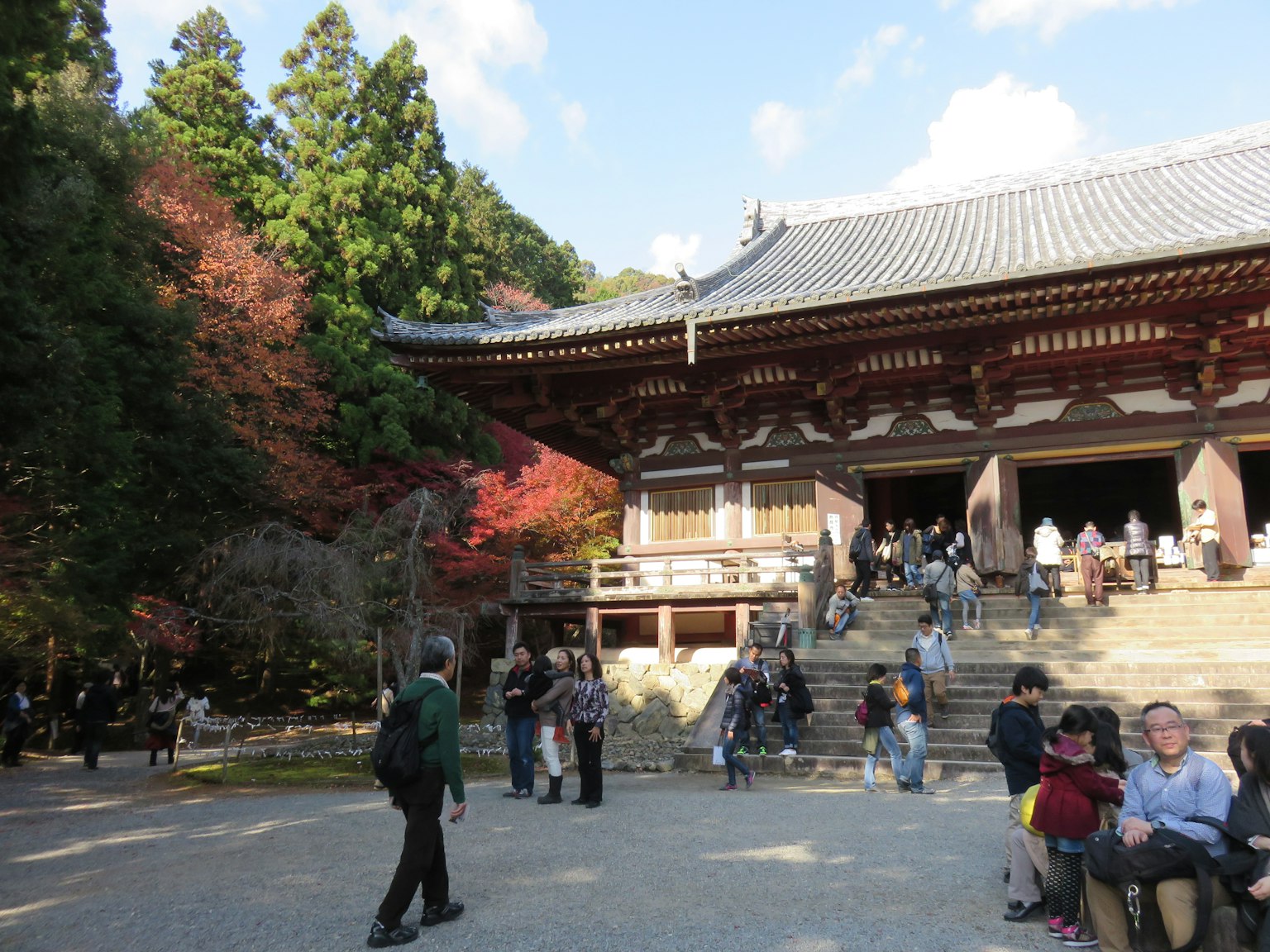 Una hermosa fachada de templo rodeada de follaje de otoño con visitantes
