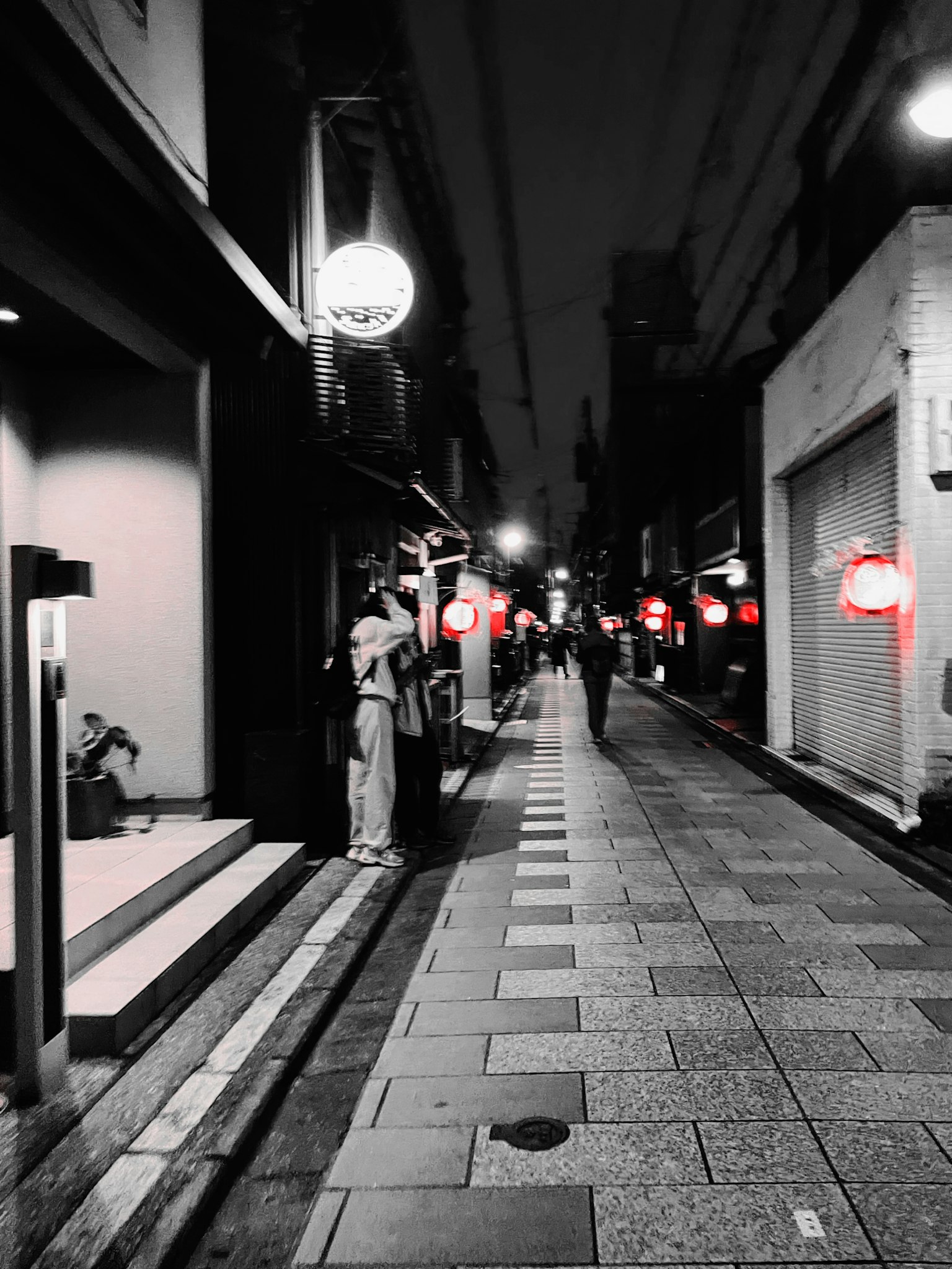 Eine Straße bei Nacht mit auffälligen roten Laternen und ruhiger Atmosphäre