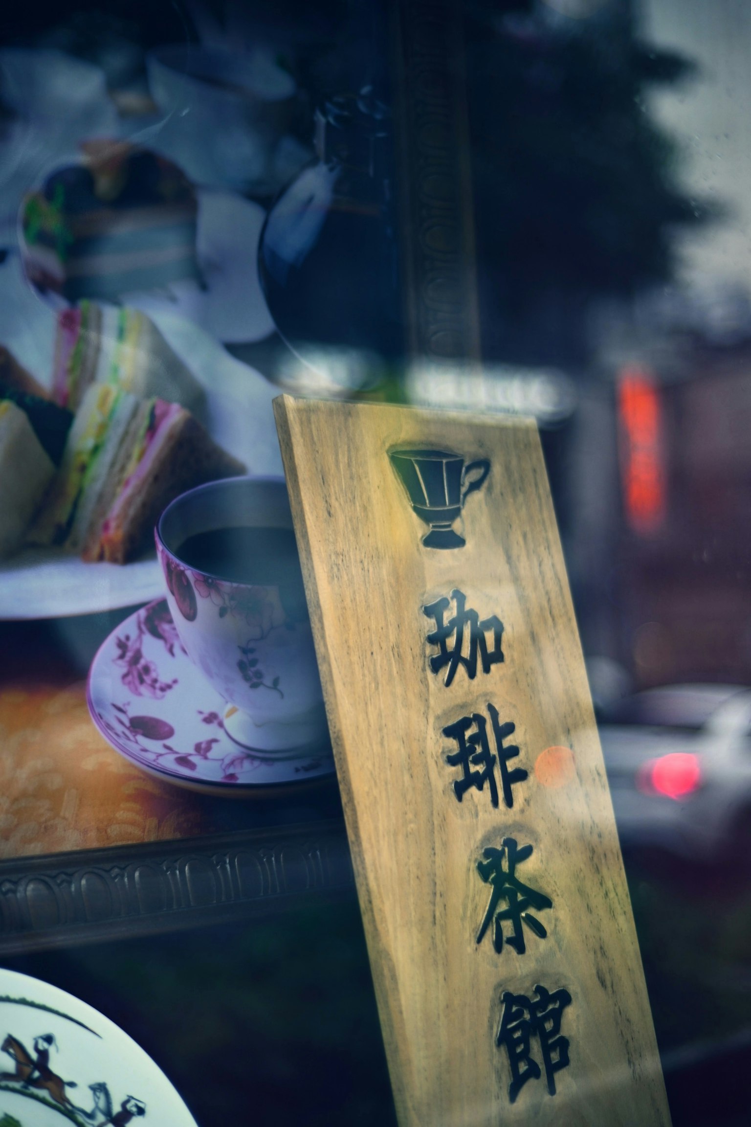 咖啡馆招牌和窗户上反射的茶杯