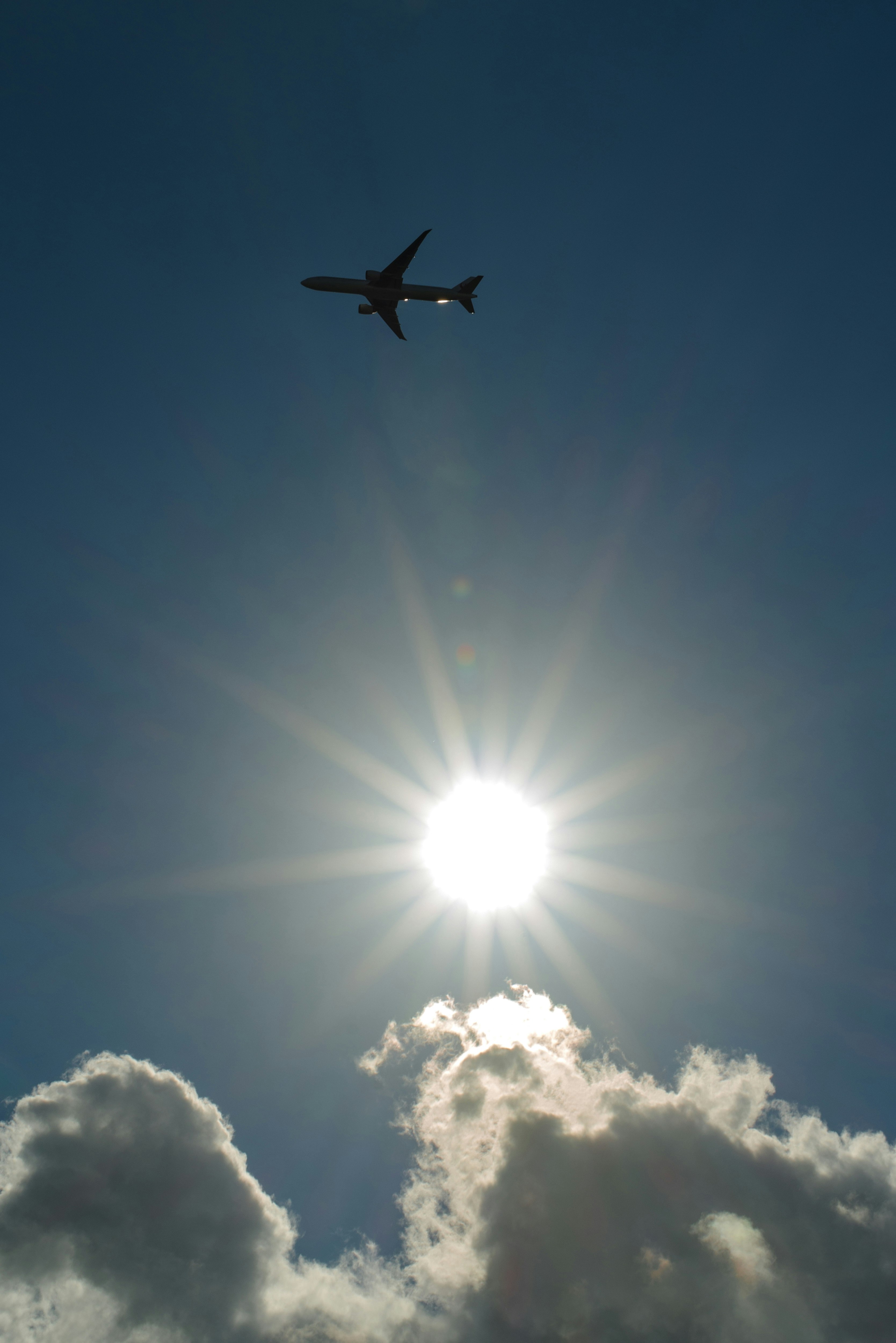 太陽光下飛行的飛機與雲層天空