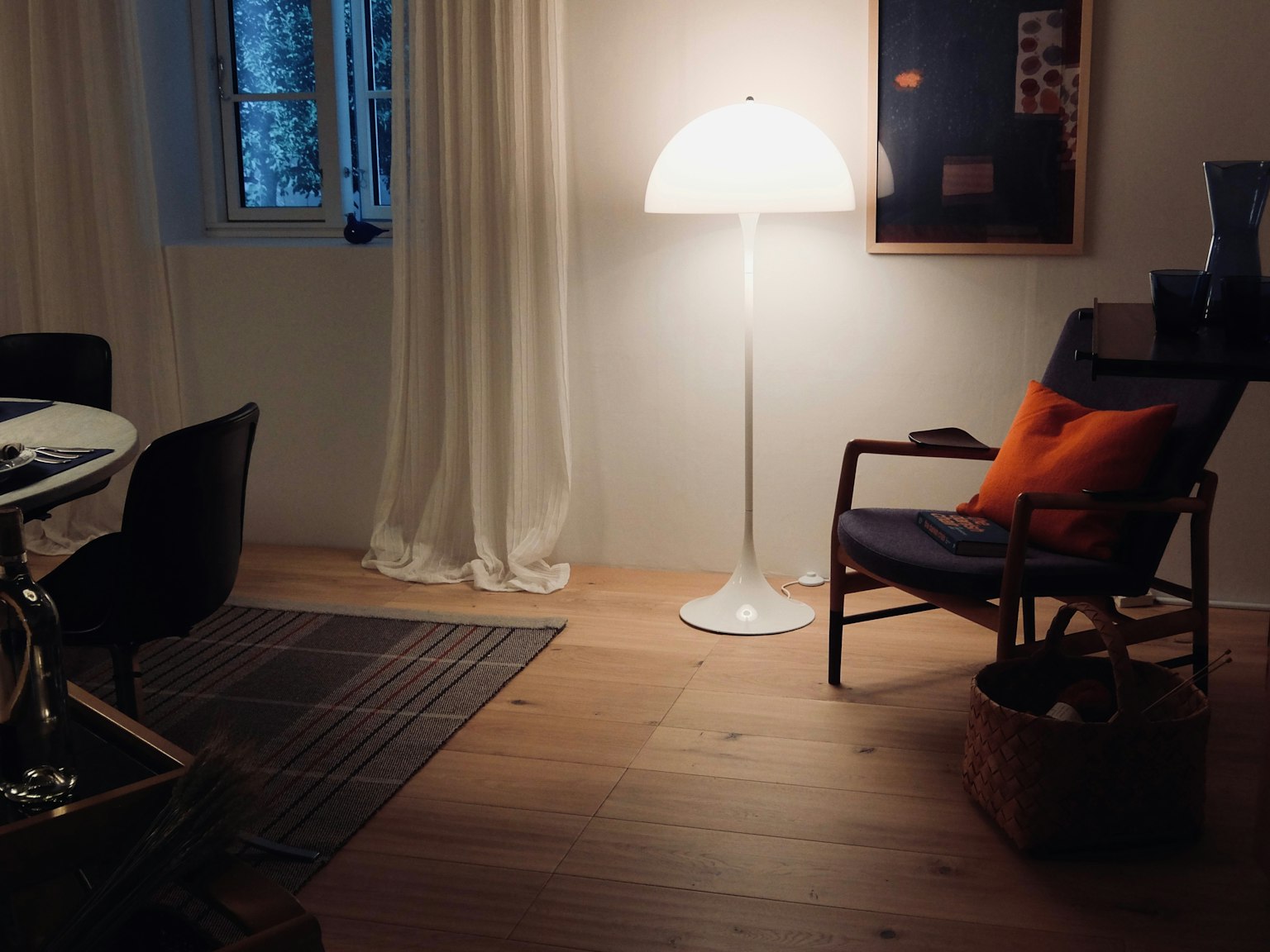 Esquina acogedora de una sala de estar con una lámpara brillante y un cojín naranja