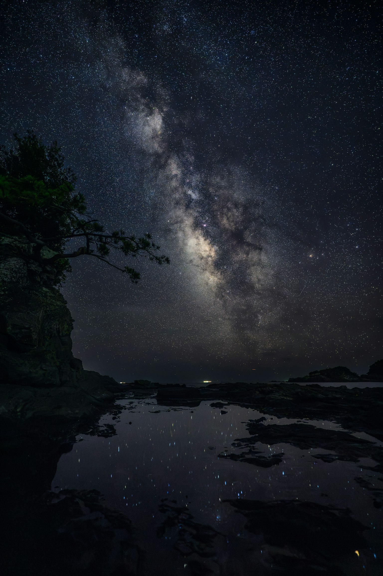 어두운 풍경 위에 빛나는 은하수와 반사된 수면