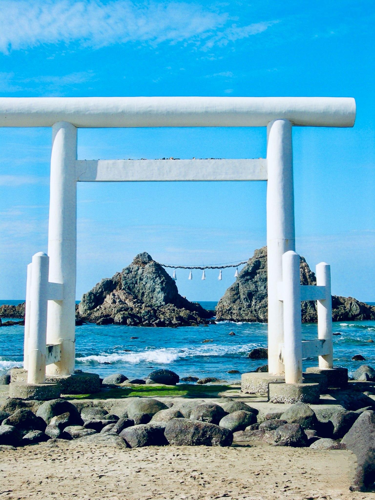 白色鸟居框住岩石岛屿和蓝色海洋