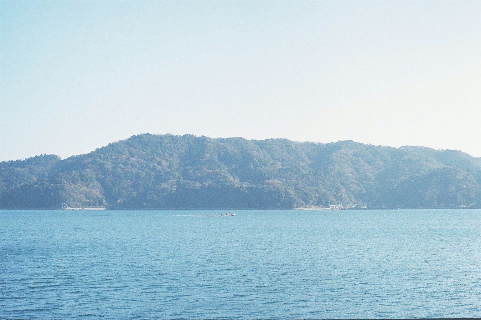 Scenic view of calm sea with distant mountains