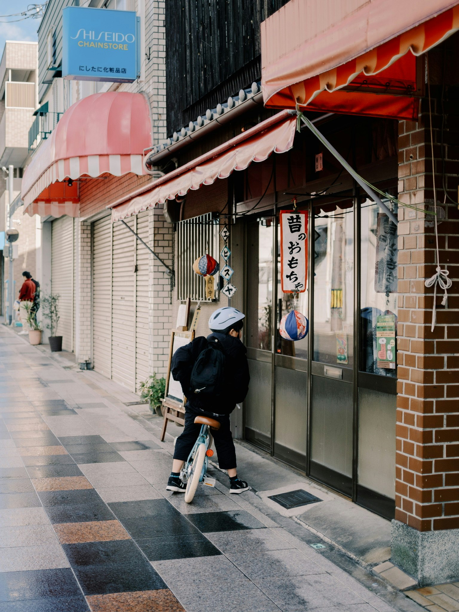 Un enfant à vélo devant un magasin dans une rue de la ville