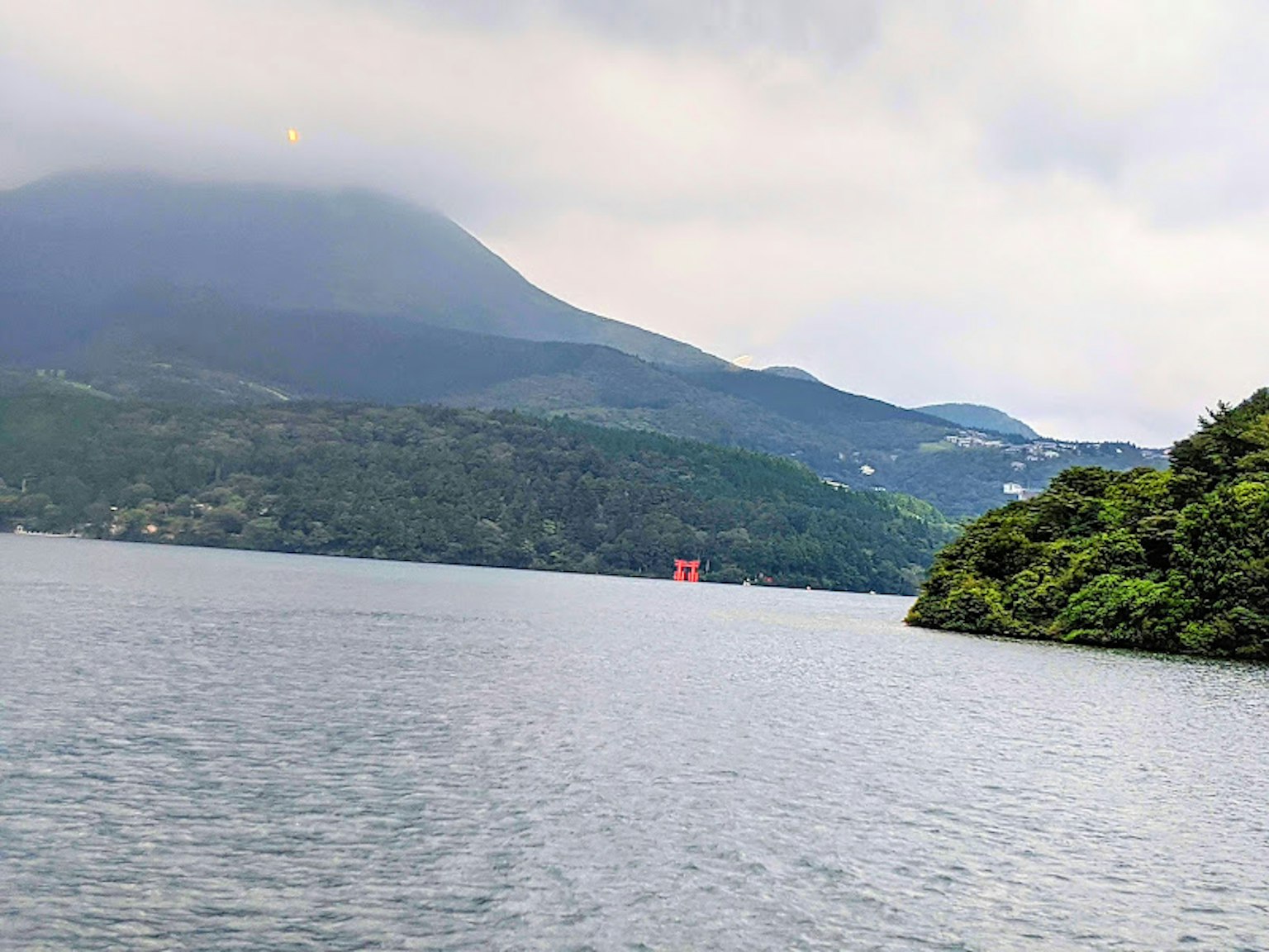 Seen- und Berglandschaft mit einem roten Torii