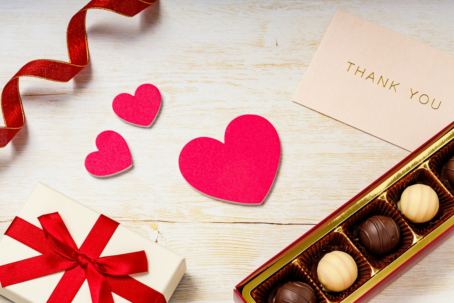 Tema di San Valentino con cuori rosa e una scatola di cioccolatini
