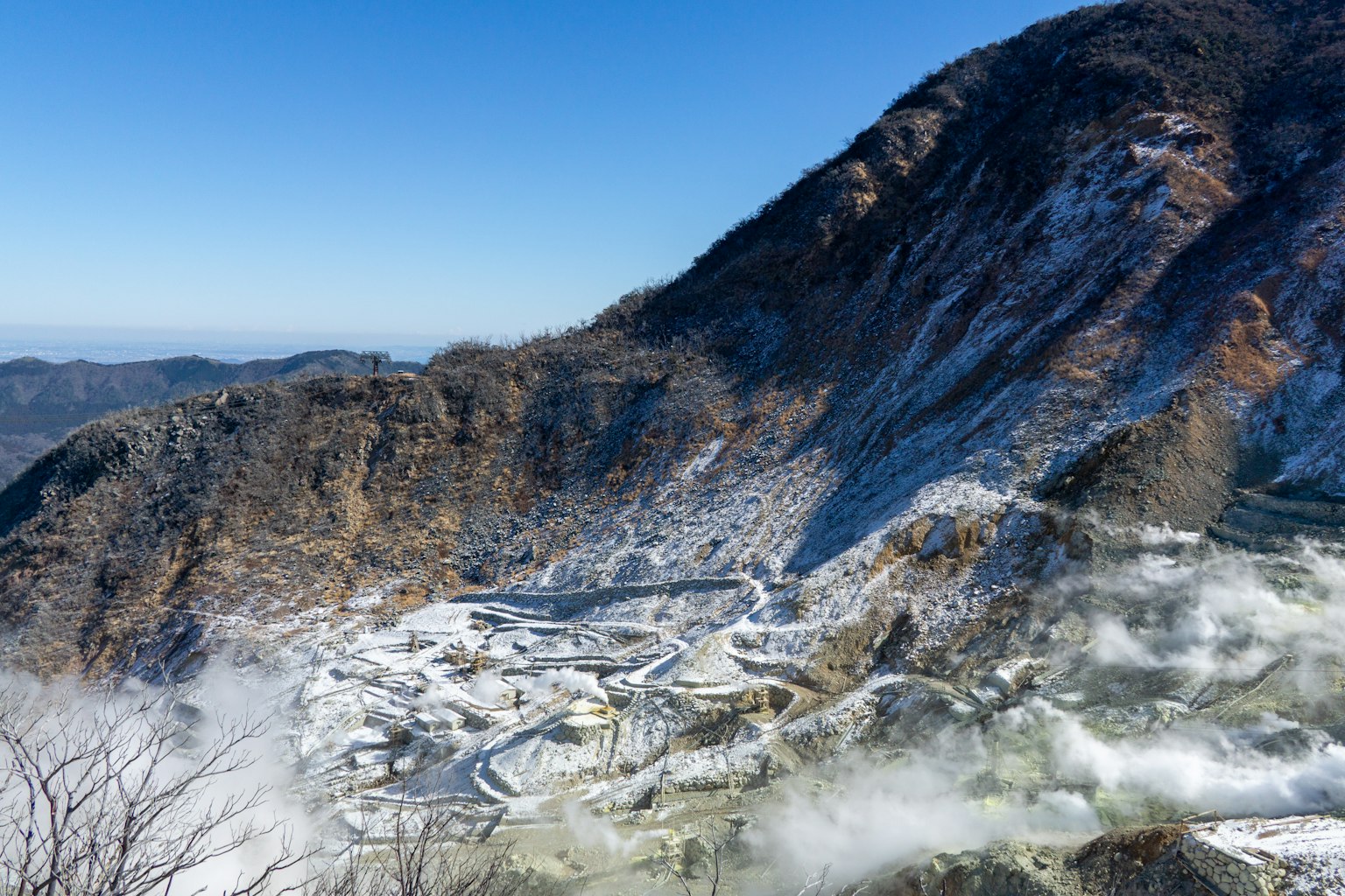 Snow-covered mountain landscape with mist and winding roads