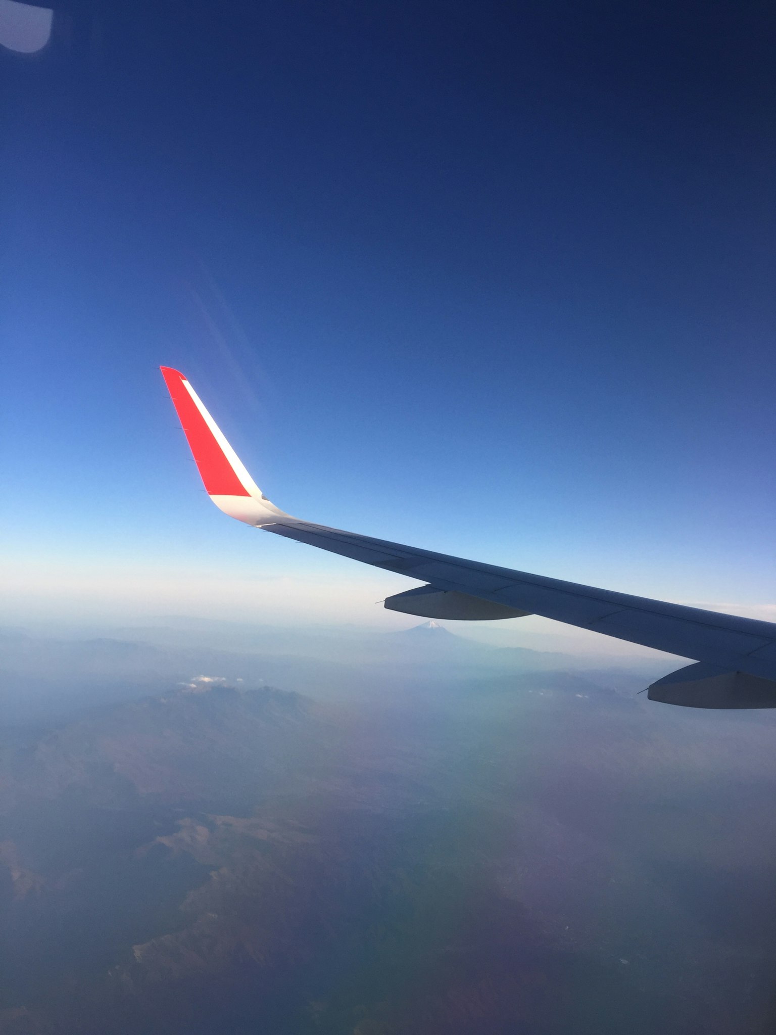 飛行機の翼と青い空の広がり