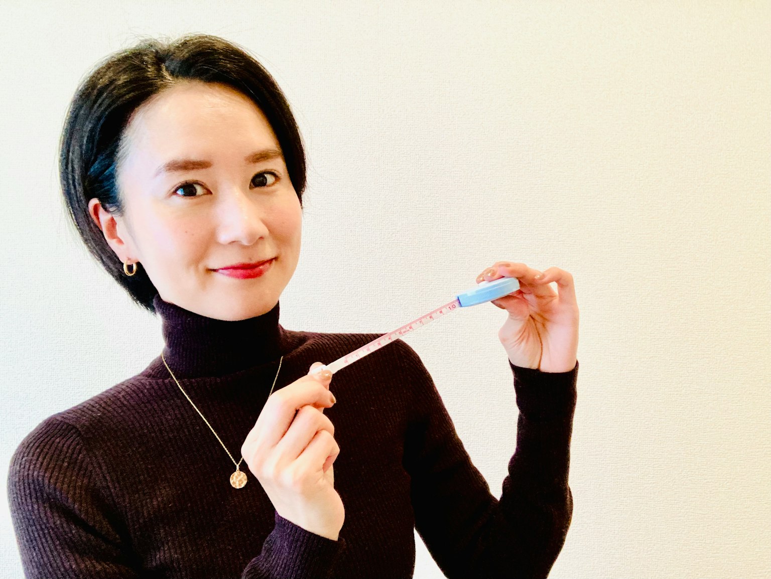 Frau lächelt und hält einen blauen Stift