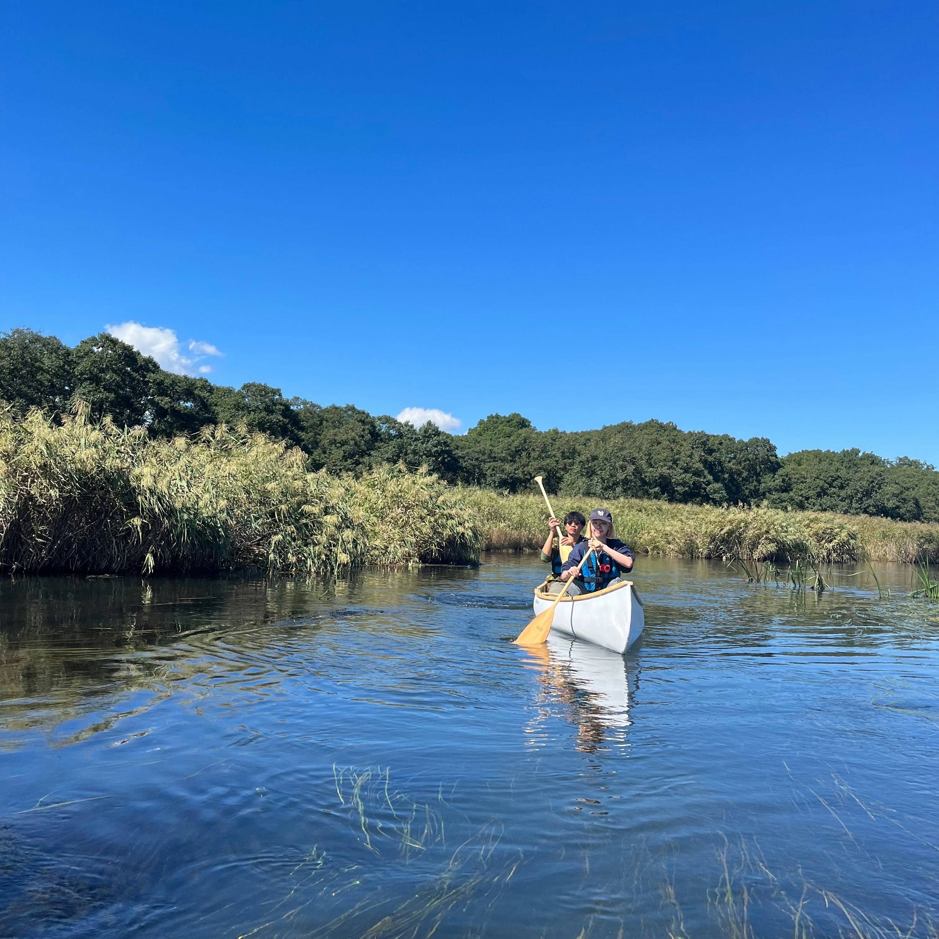 parent et enfant en canoë sur une rivière calme