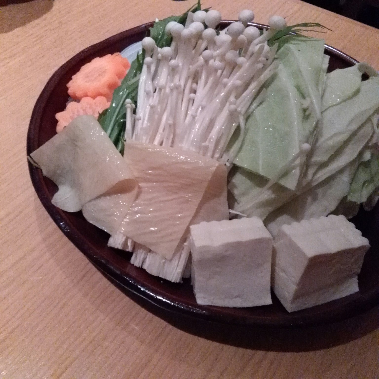 A plate of fresh vegetables and tofu arranged beautifully