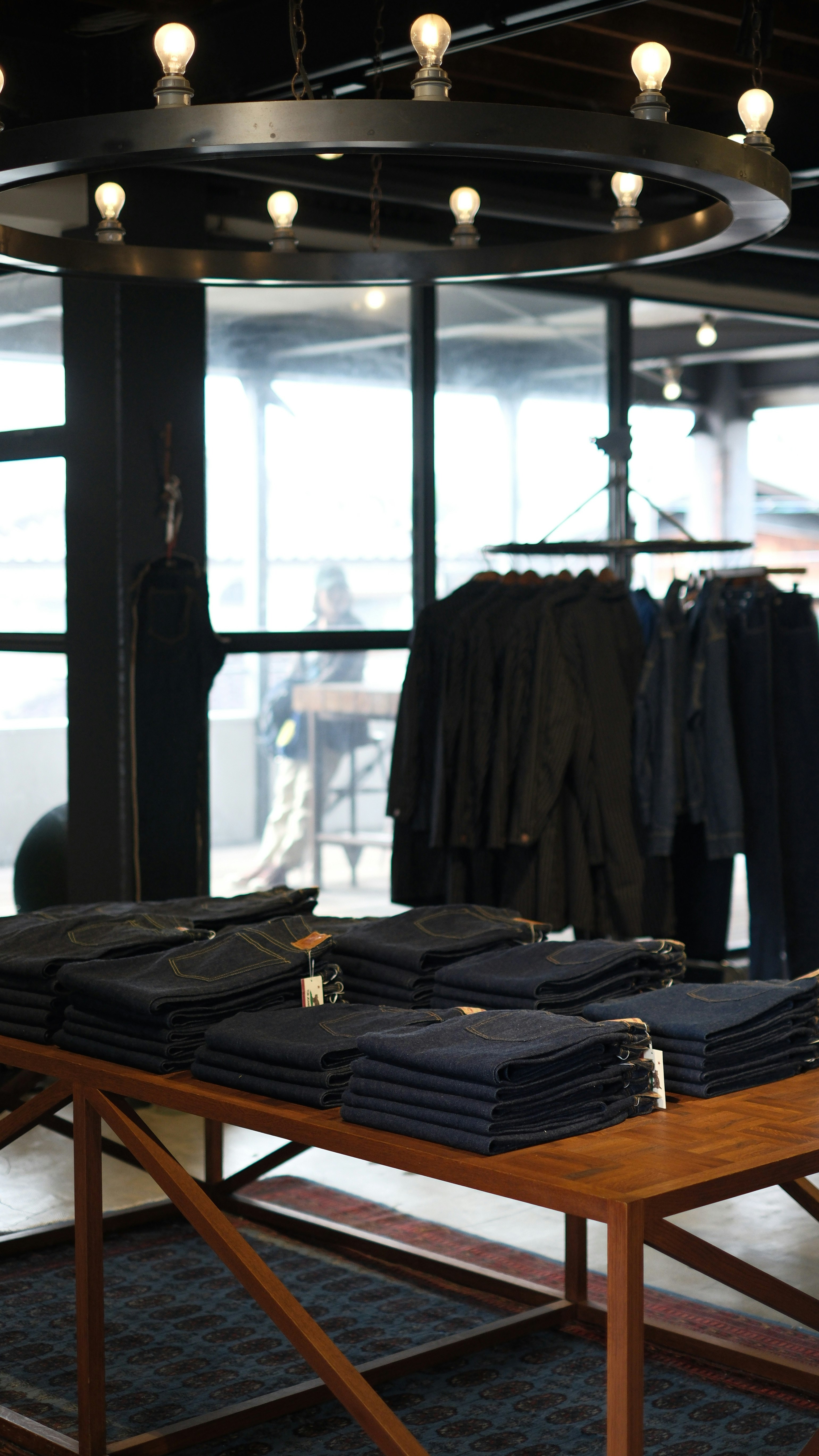 Quần jeans và quần áo gấp trên kệ trưng bày gỗ trong cửa hàng