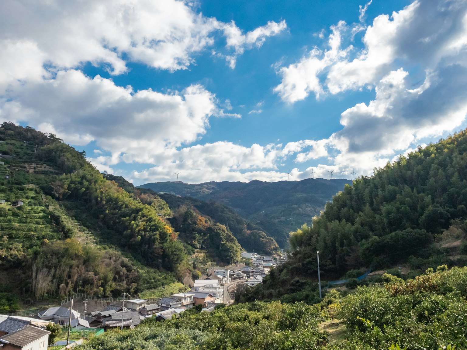 Vue pittoresque d'un village tranquille entouré de montagnes et d'un ciel bleu