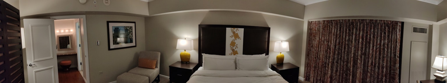 Camera d'hotel moderna con letto queen arte e tende