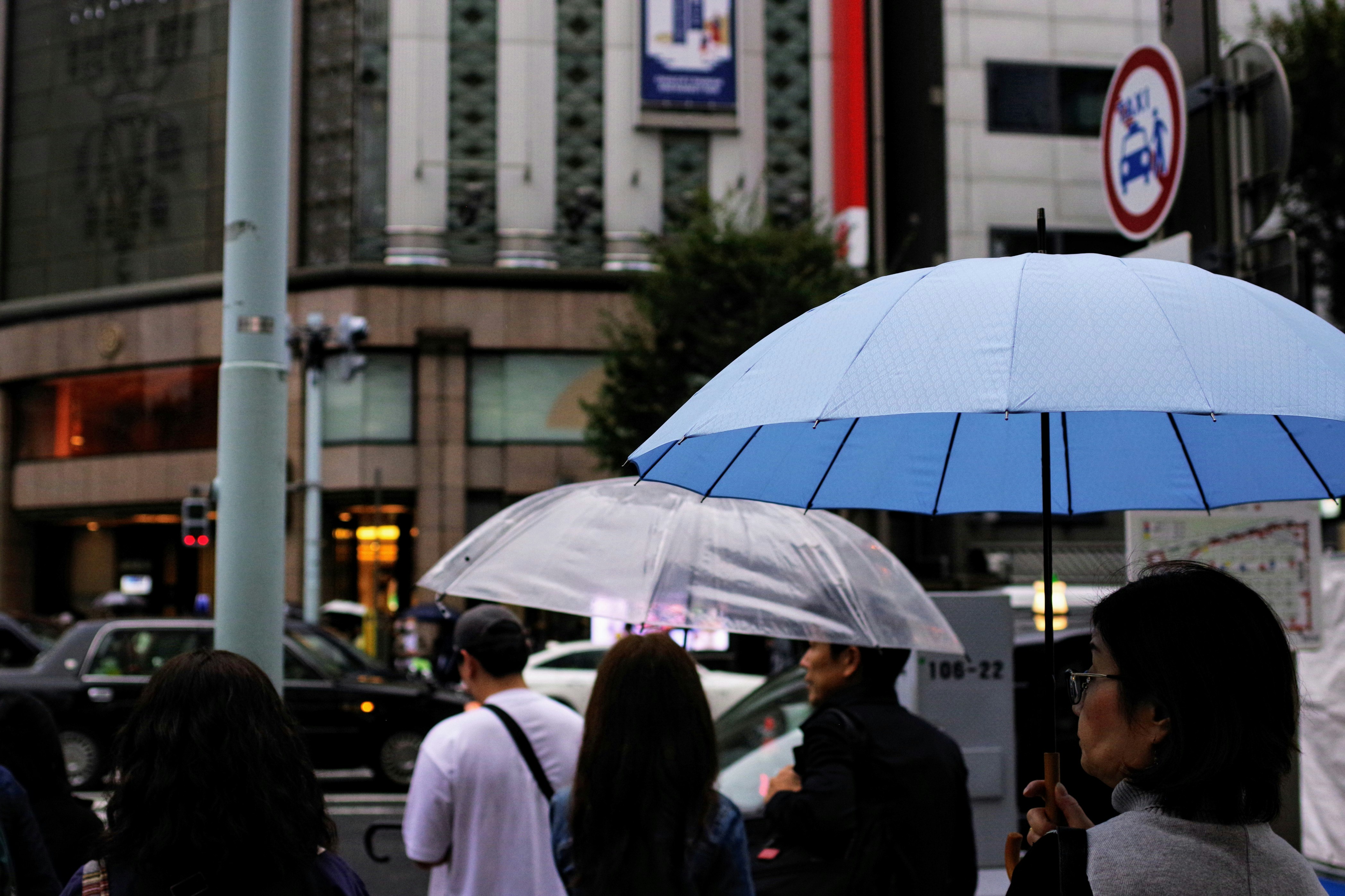 雨の街角で傘をさす人々のストリート風景