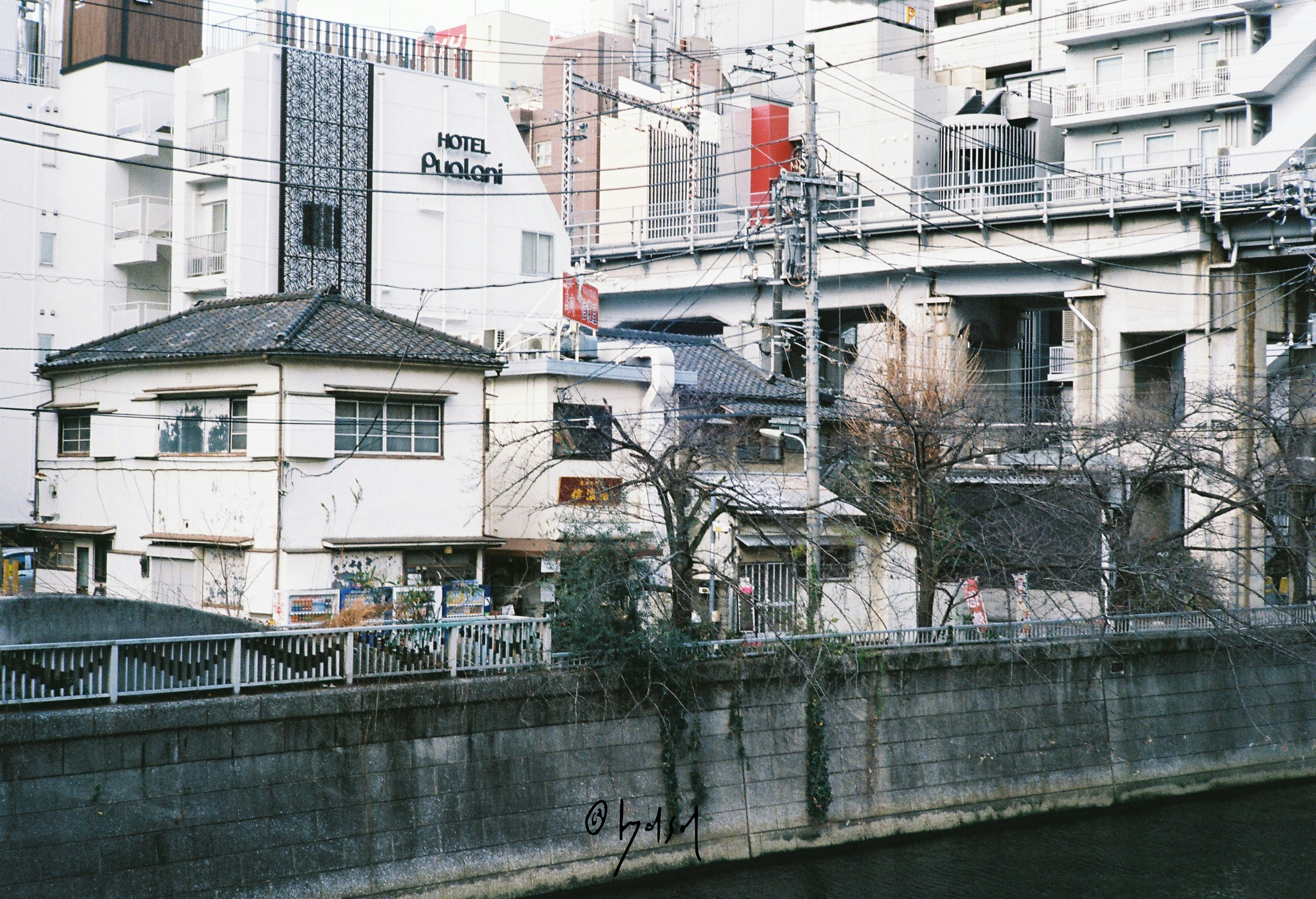 川沿いの高架と住宅・ホテルが混在する街並み