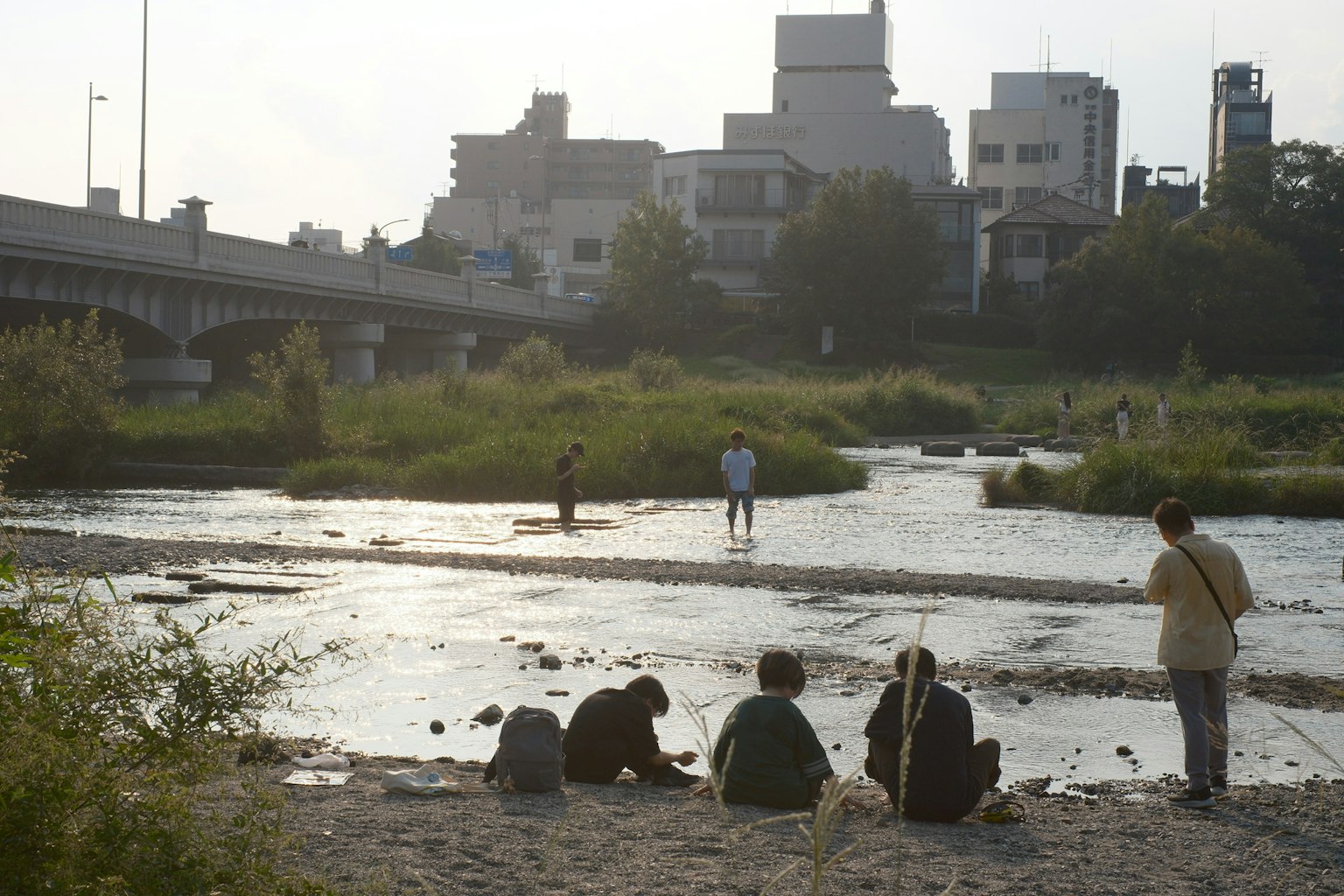 川辺で座っている人々と都市の風景