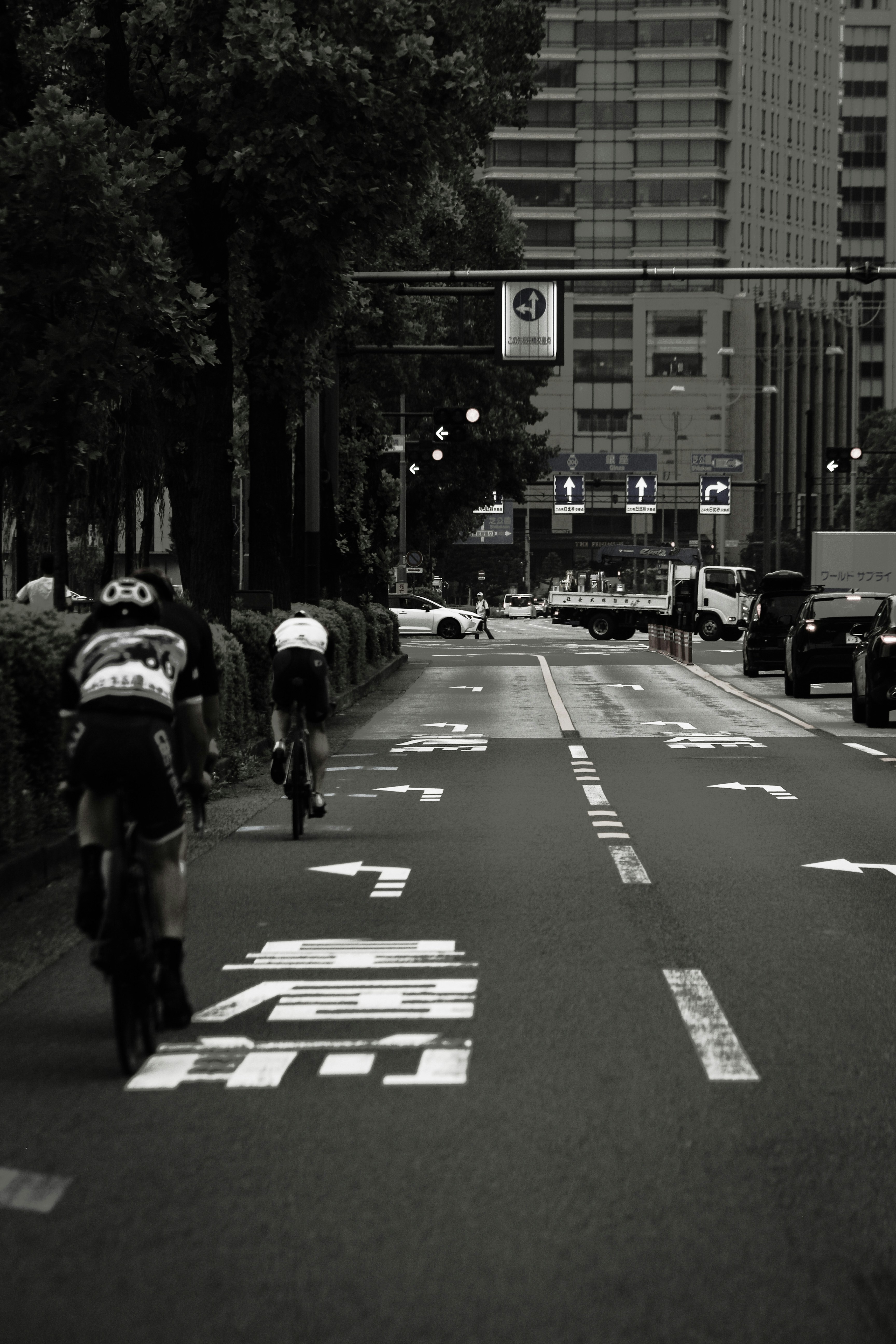 東京の街路を走る自転車と車のある交差点の風景