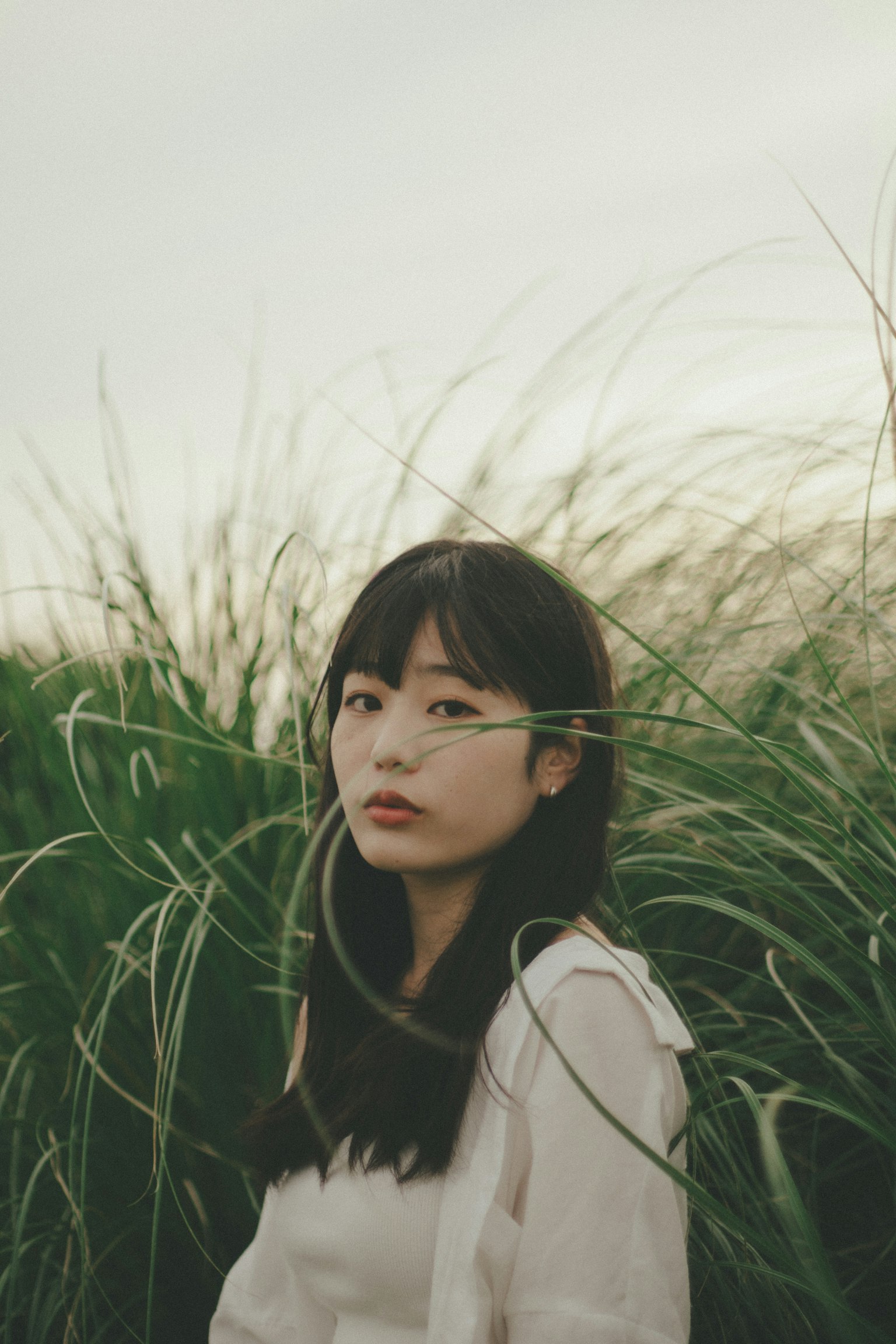 A woman gazing amidst tall grass