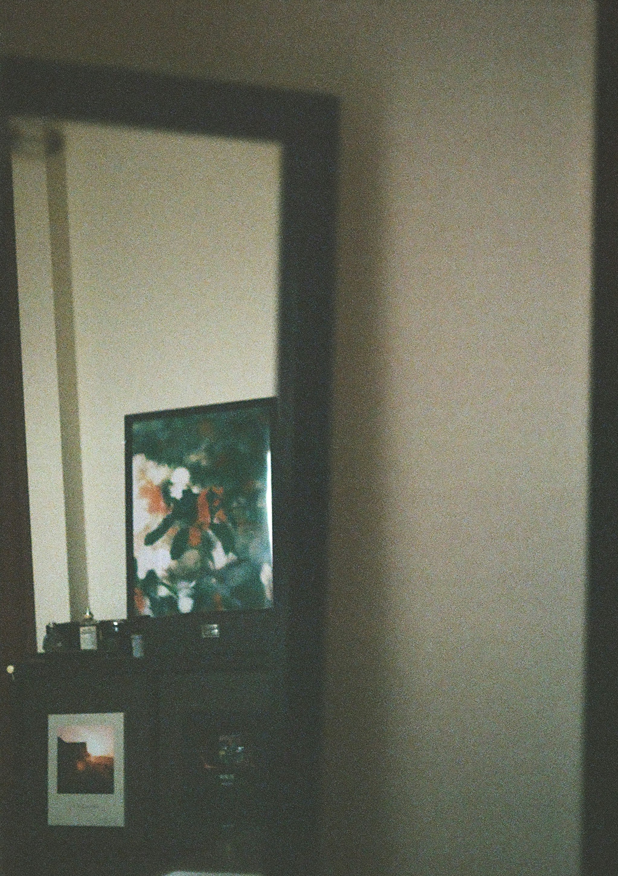 室内の壁に掛かった絵画と小さな棚のあるコーナー