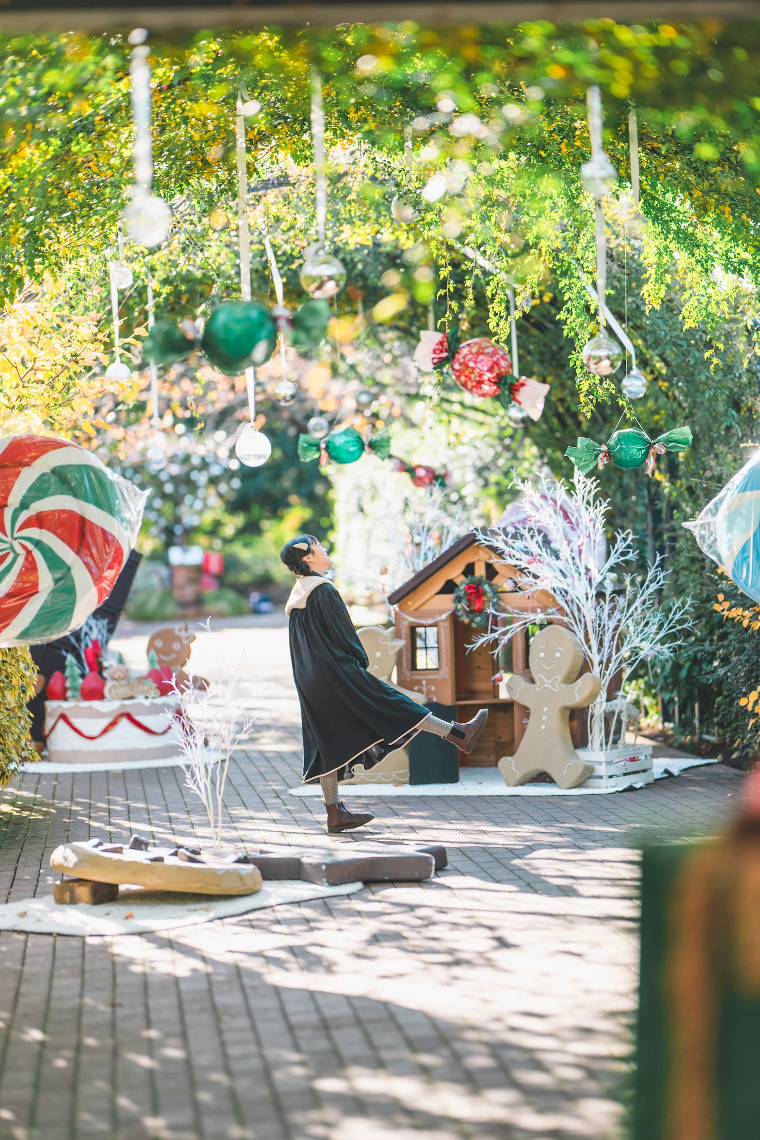 Area dekorasi Natal luar ruangan dengan ornamen berwarna-warni dan rumah jahe