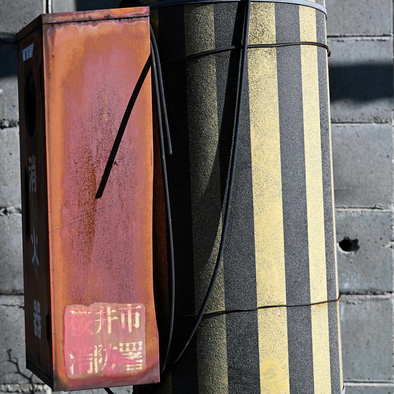 Boîte rouillée et poteau rayé dans un cadre urbain