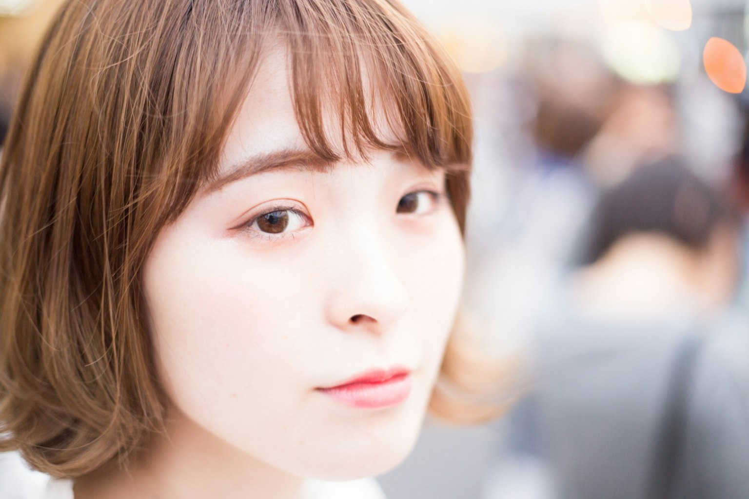 여성의 얼굴을 가까이에서 촬영한 이미지 짧은 갈색 머리와 인상적인 눈