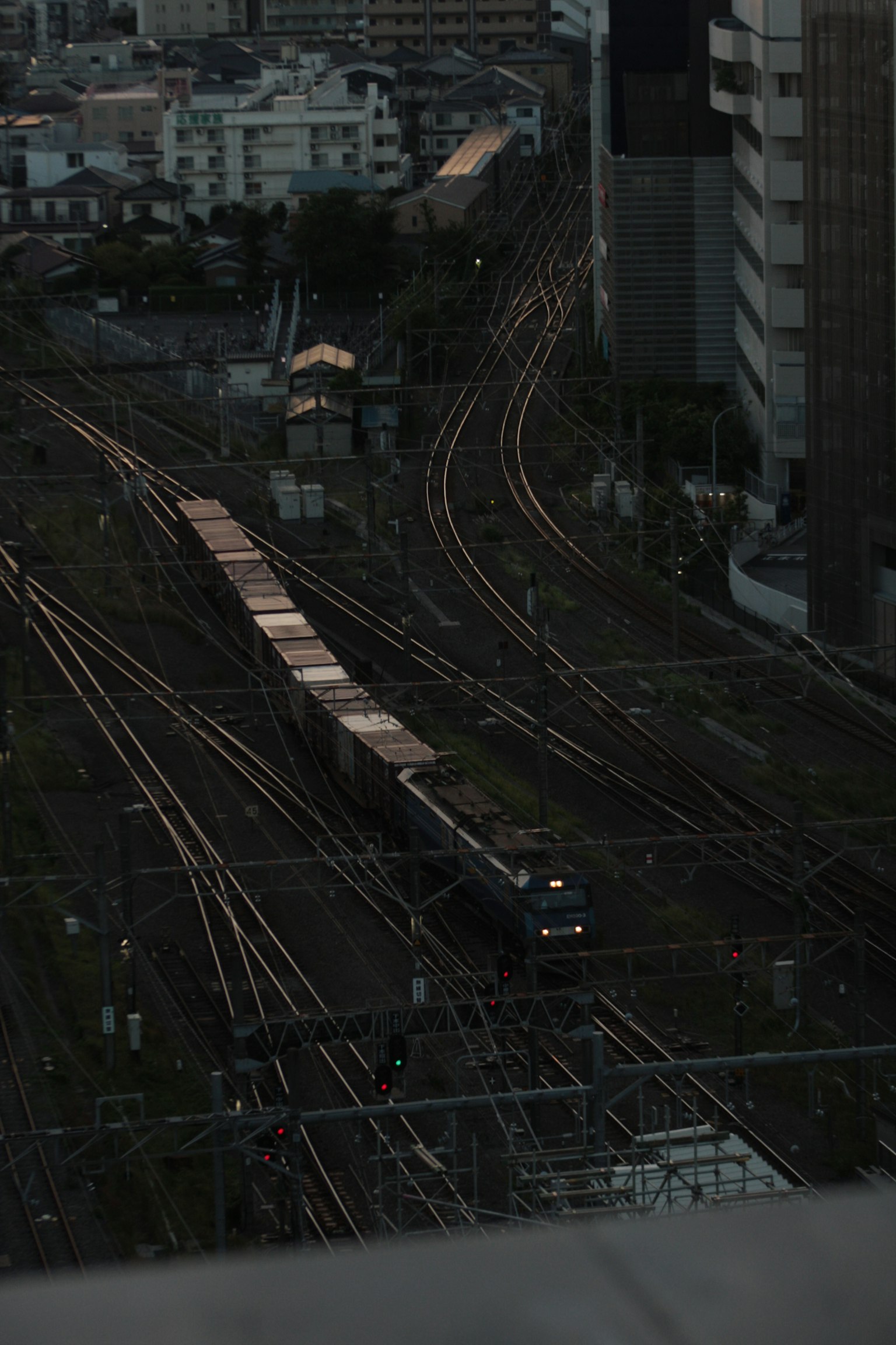 Vista nocturna de las vías del tren y edificios de la ciudad
