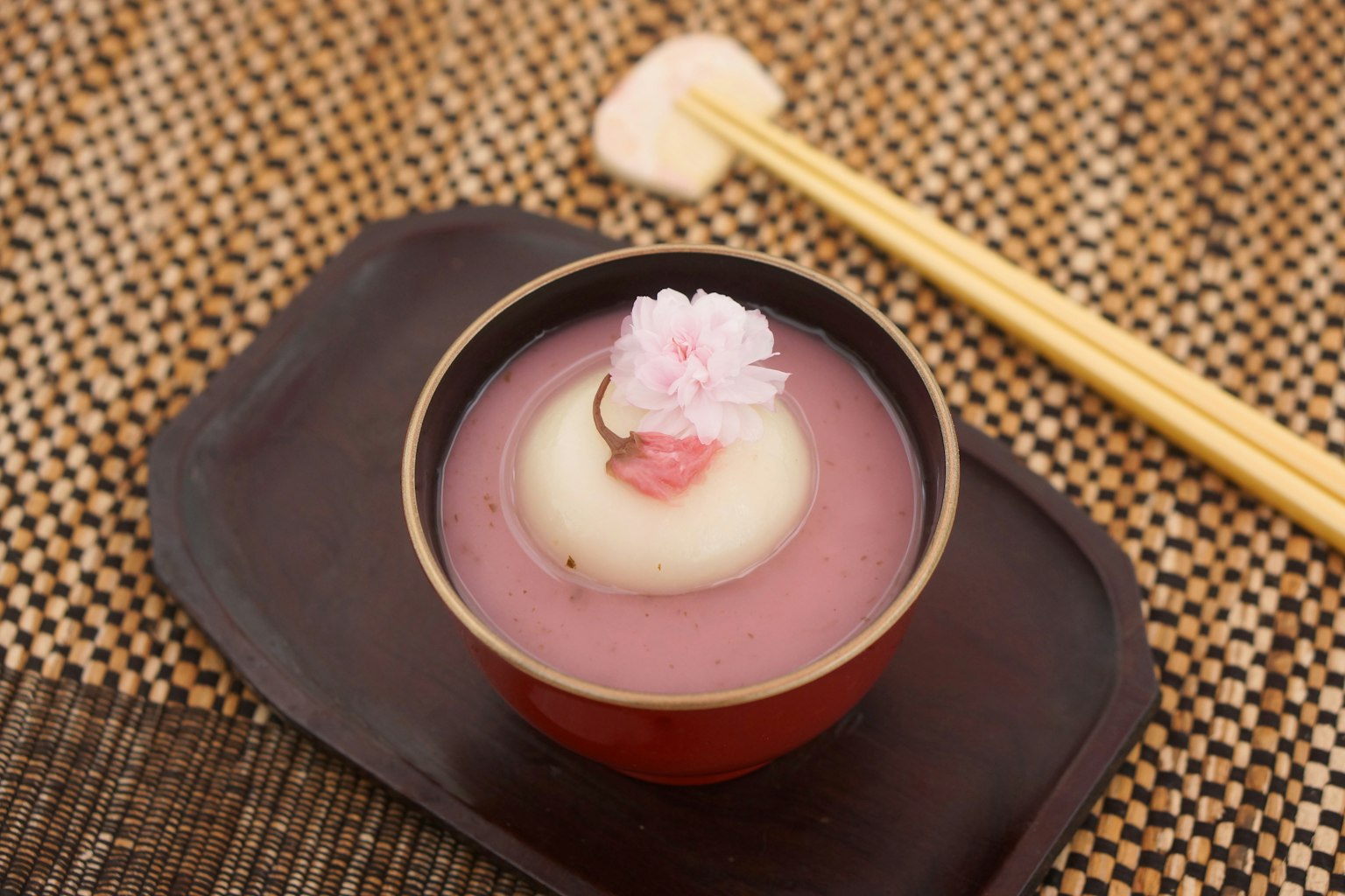 Beautiful Japanese sweets served in a red bowl with chopsticks