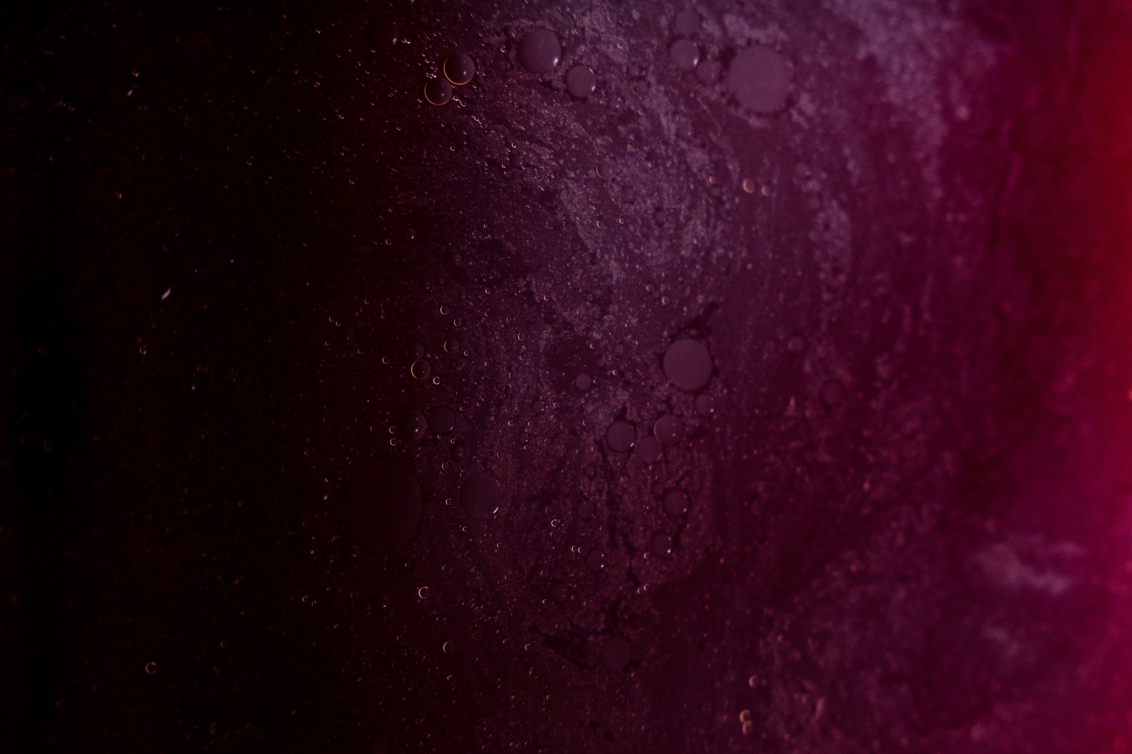 macro background of purple liquid with water droplets