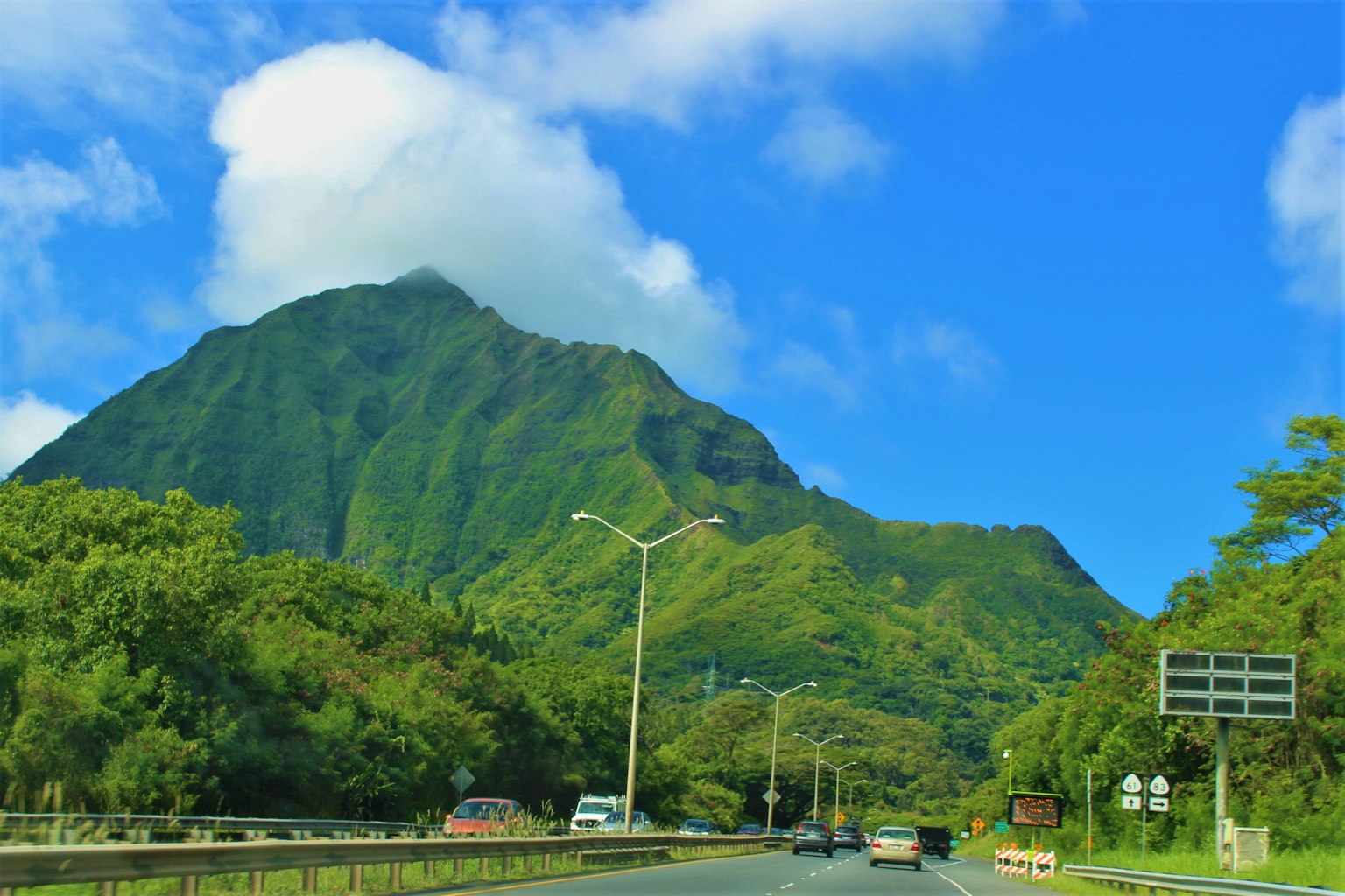 Scenic view of a lush green mountain under a blue sky