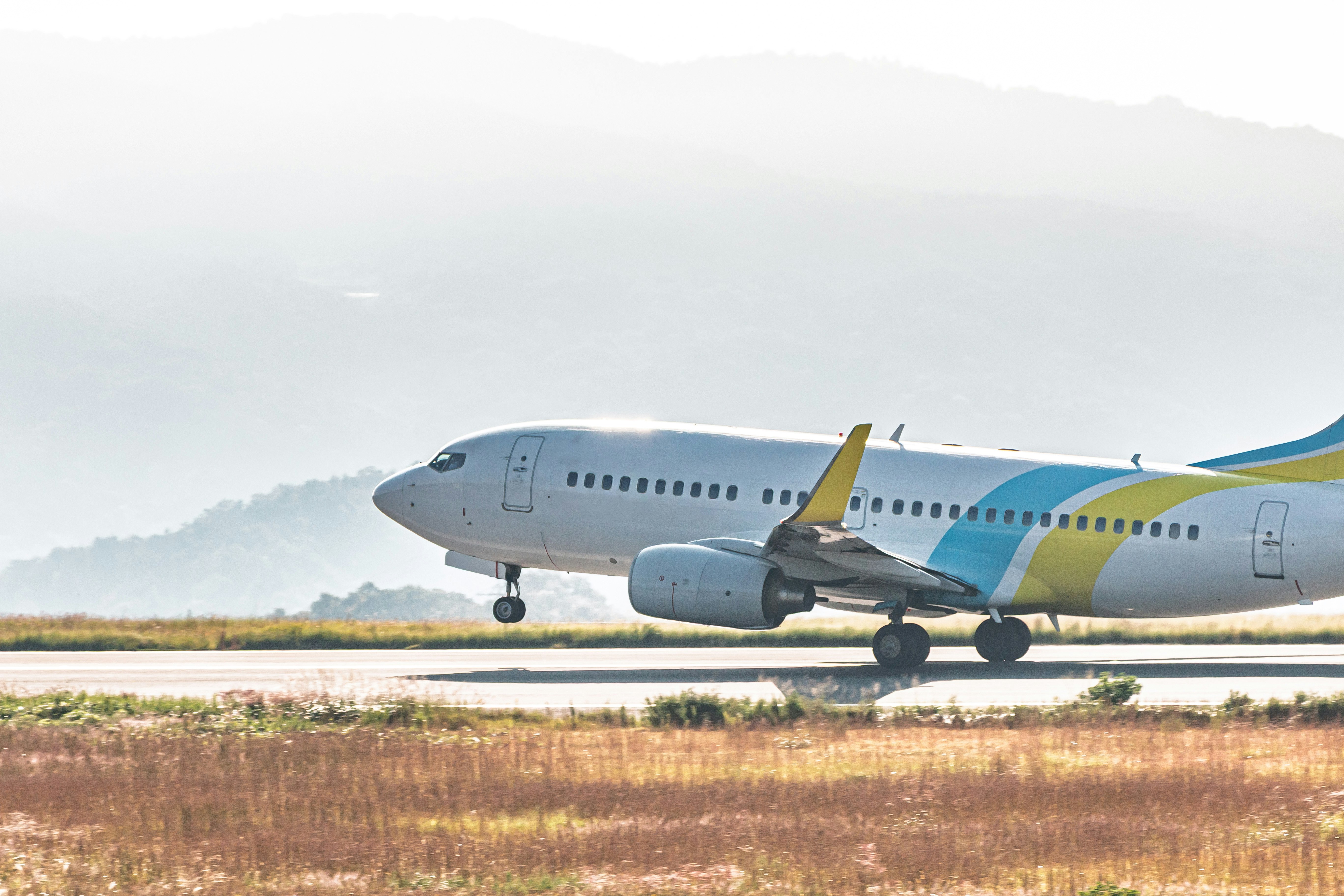 霧の中を滑走路を走る旅客機の横姿