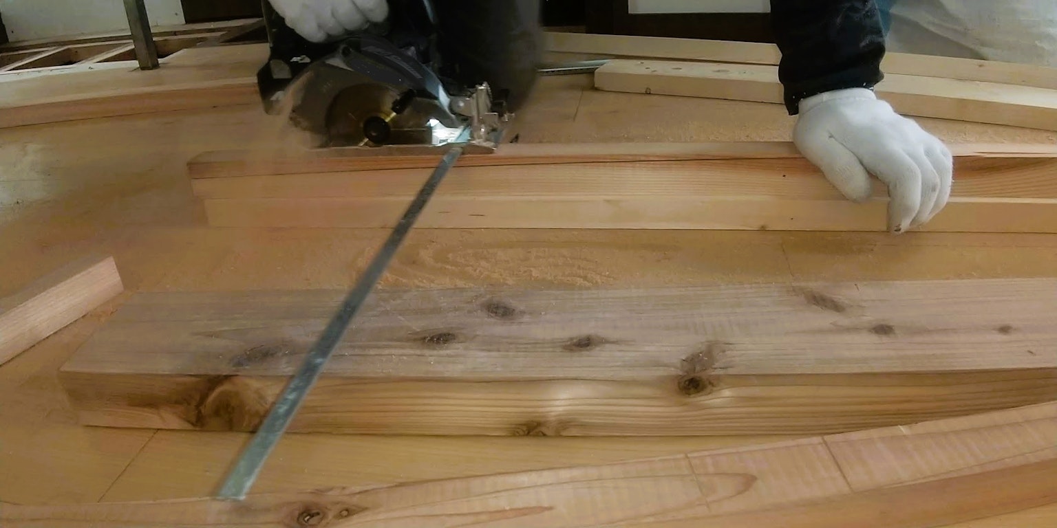 ภาพระยะใกล้ของคนงานที่ตัดไม้ด้วยเลื่อยไฟฟ้า