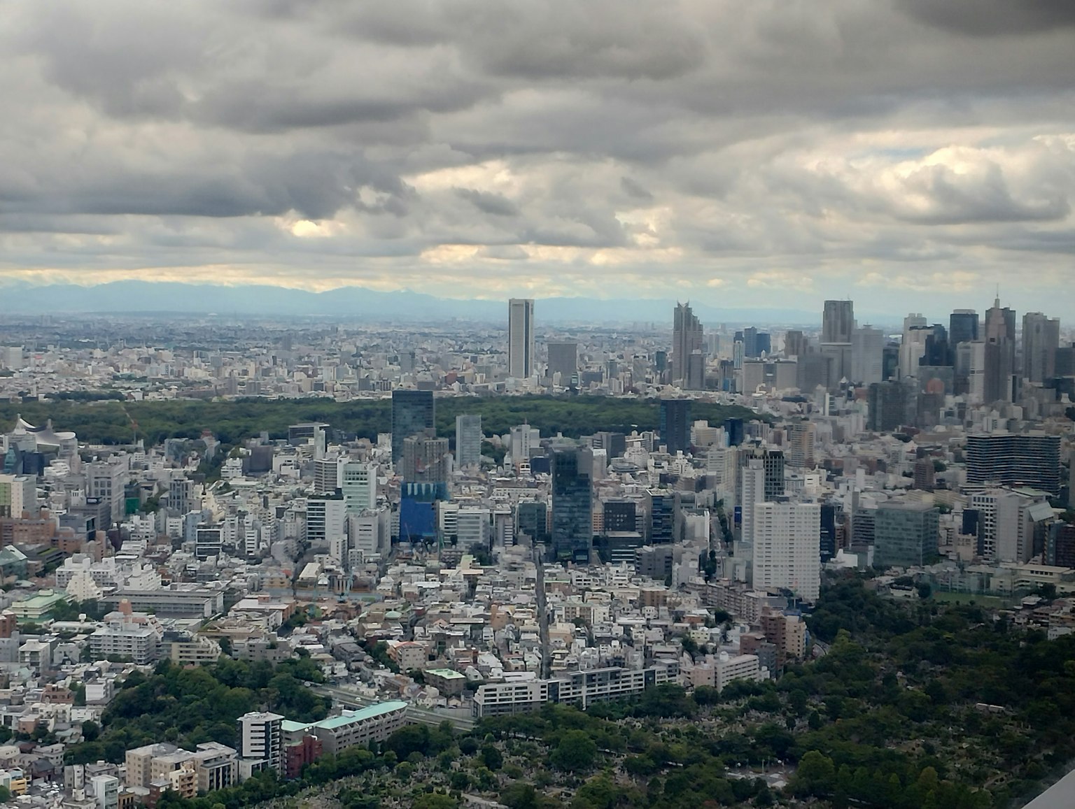 Luftaufnahme der Skyline von Tokio mit Stadtgebäuden und bewölktem Himmel